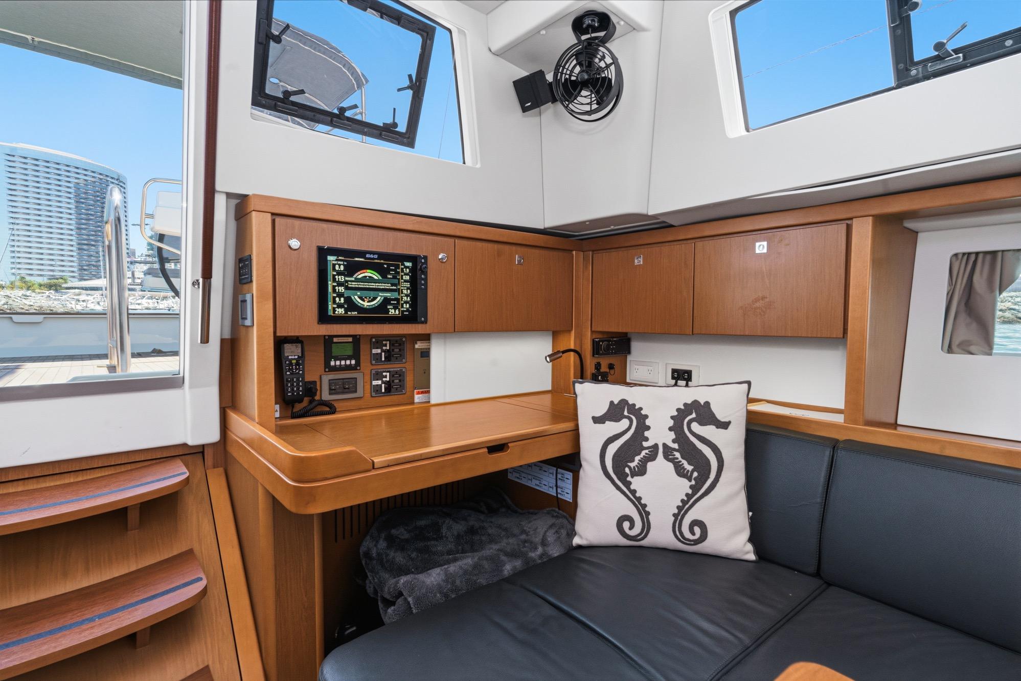Interior of 2017 Beneteau Sense 50 yacht with navigation station and seahorse pillow.