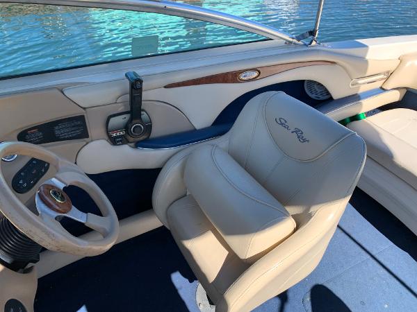 Interior of a 2000 Sea Ray 210 Bow Rider boat with steering wheel and captain's chair.
