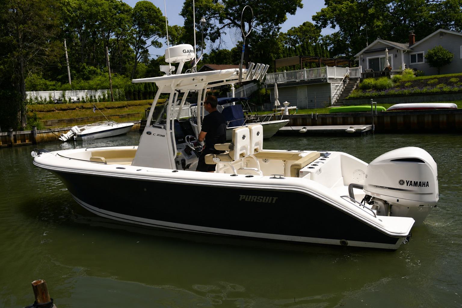2020 Pursuit C 238 Center Console boat with Yamaha engine on a calm waterway.
