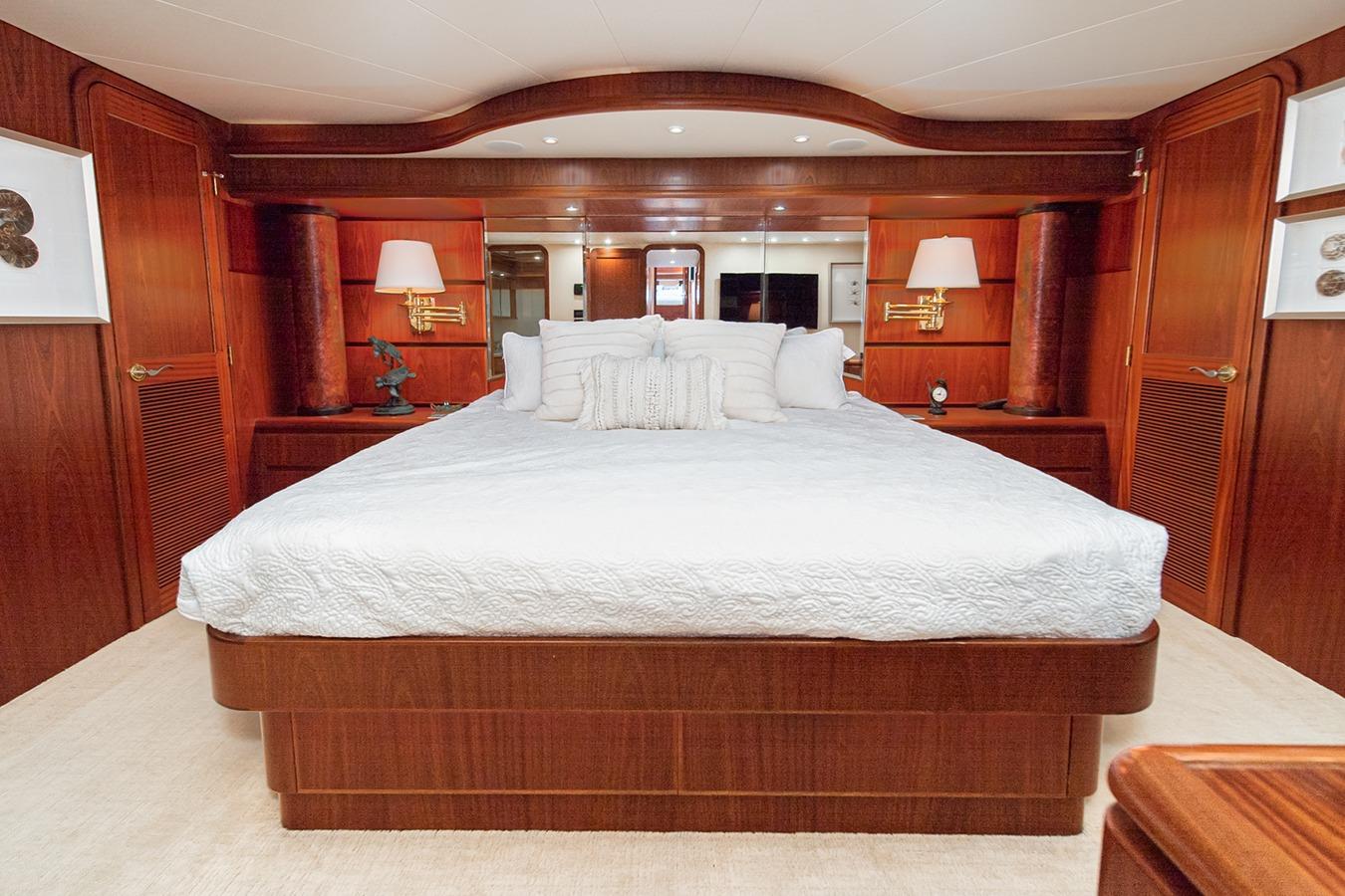 Luxurious 2003 West Bay Sonship yacht bedroom with elegant wood paneling and plush bedding.
