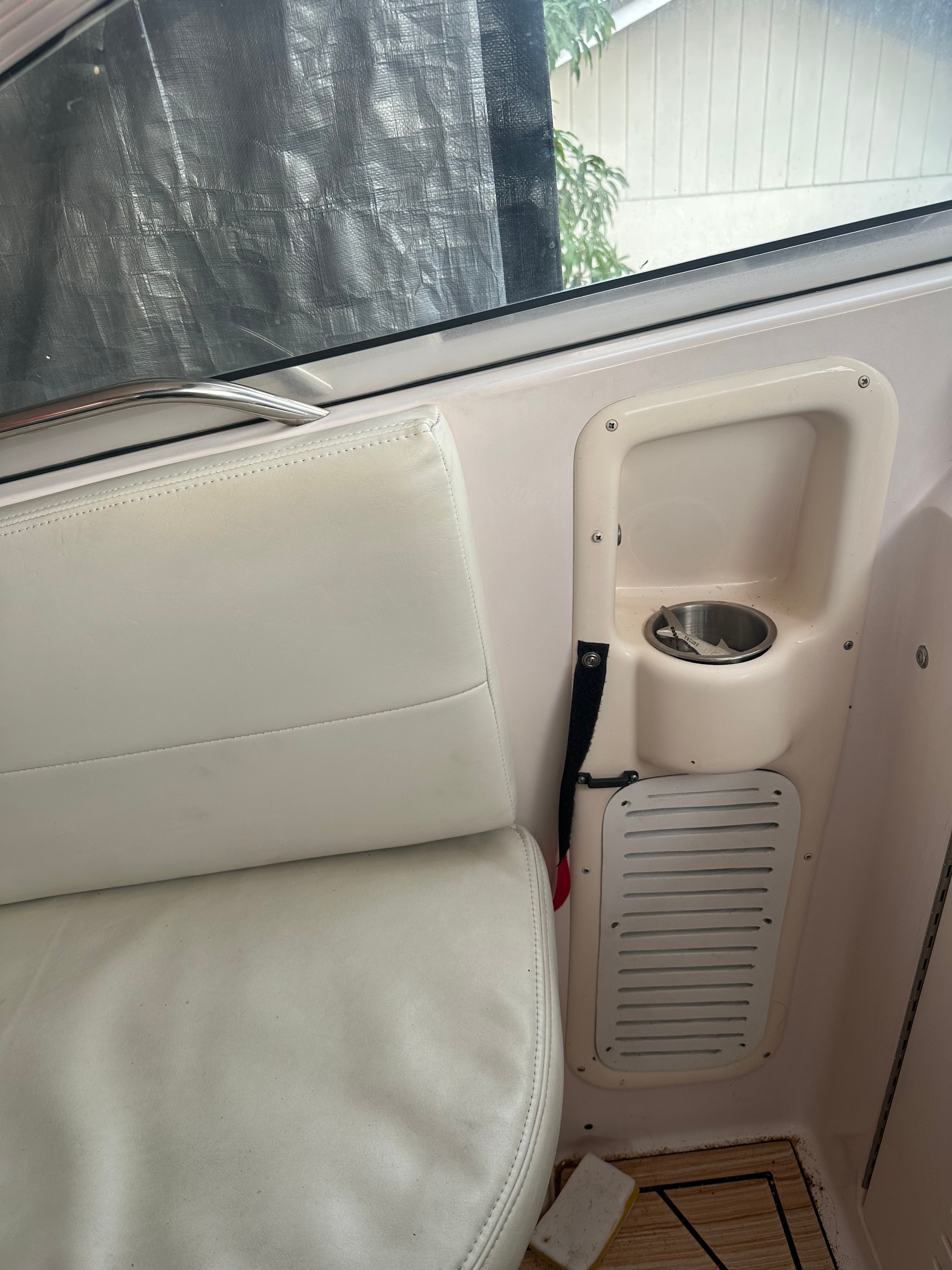 Interior view of a boat with a white seat and cup holder.