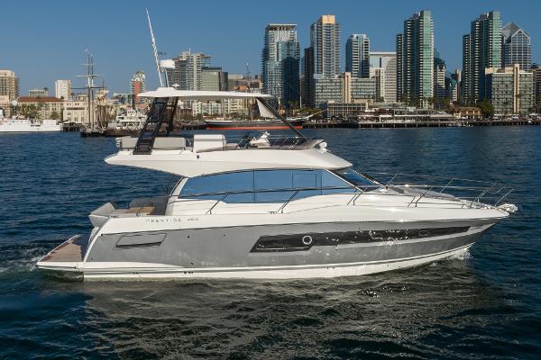 2023 Prestige 460 luxury yacht cruising near city skyline.