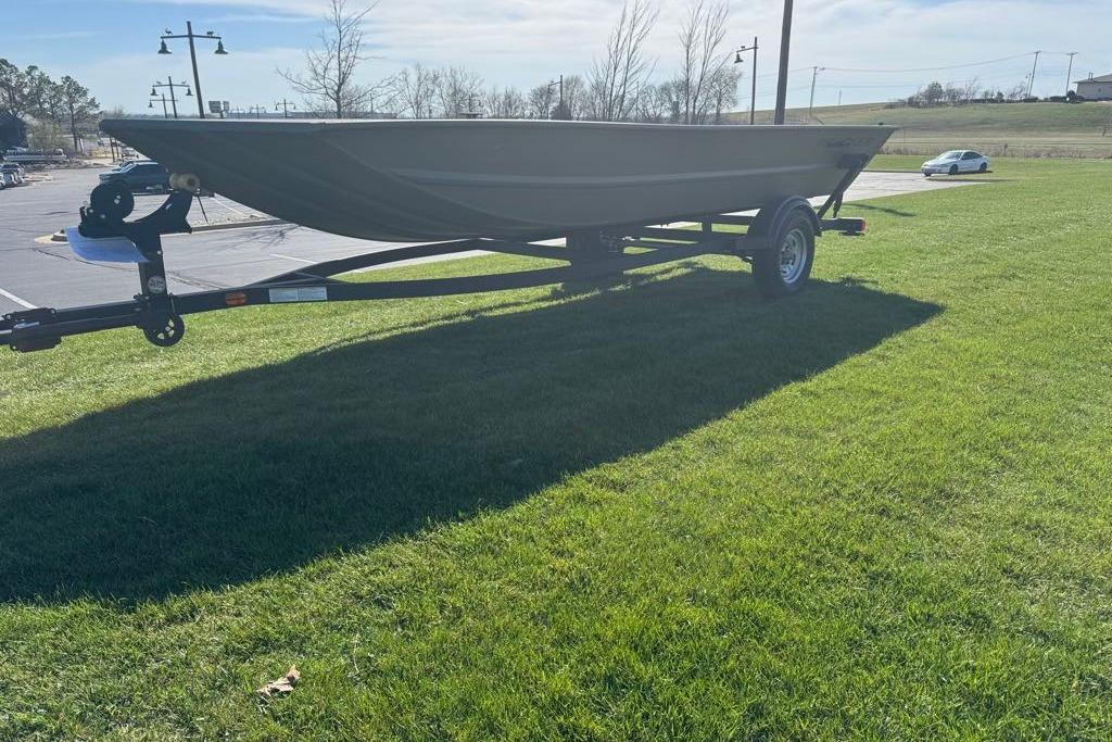 2026 Tracker Grizzly 1754 Utility boat on trailer, parked on grassy area.