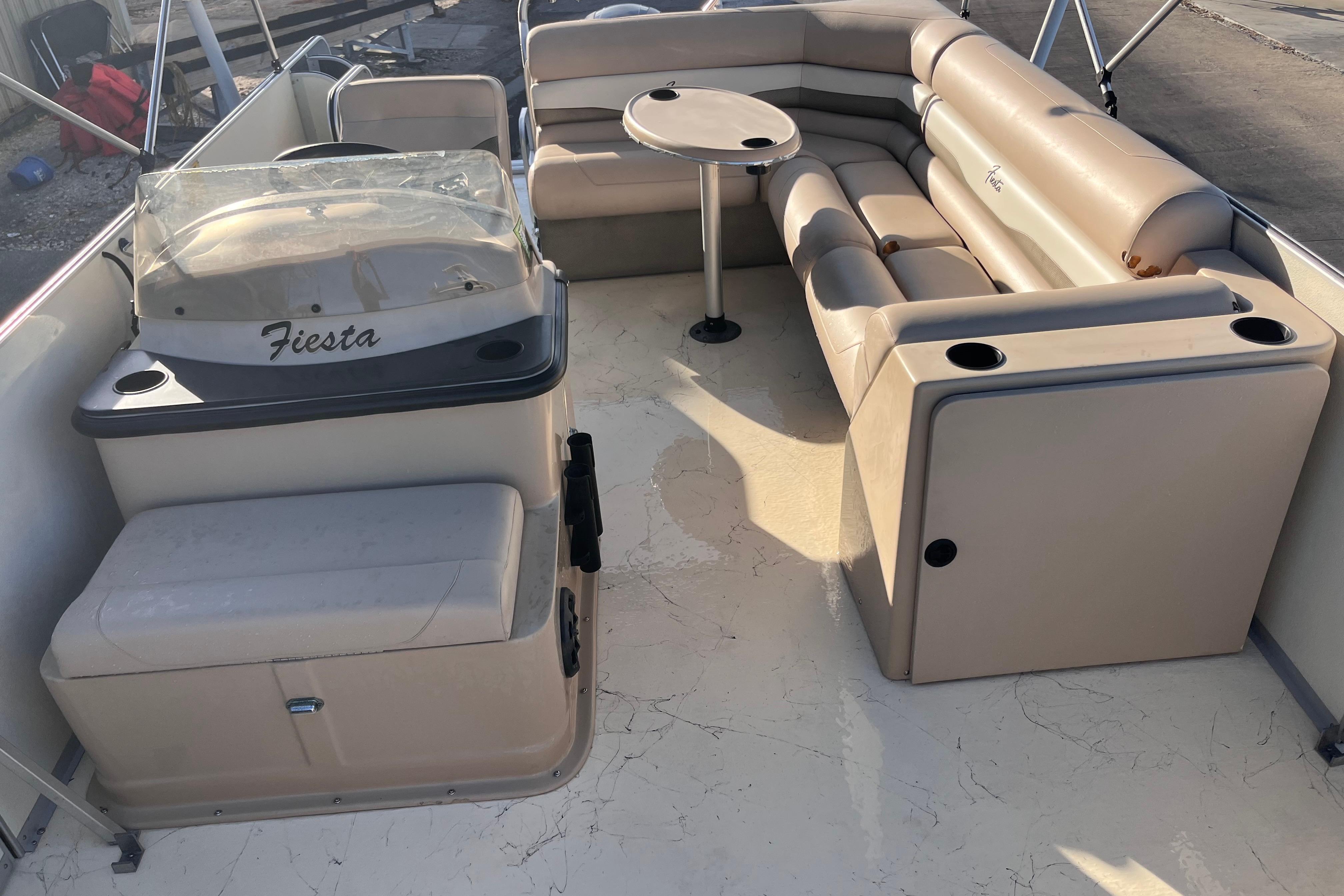2017 Fiesta 22 Beachcomber boat interior with beige seating and table.