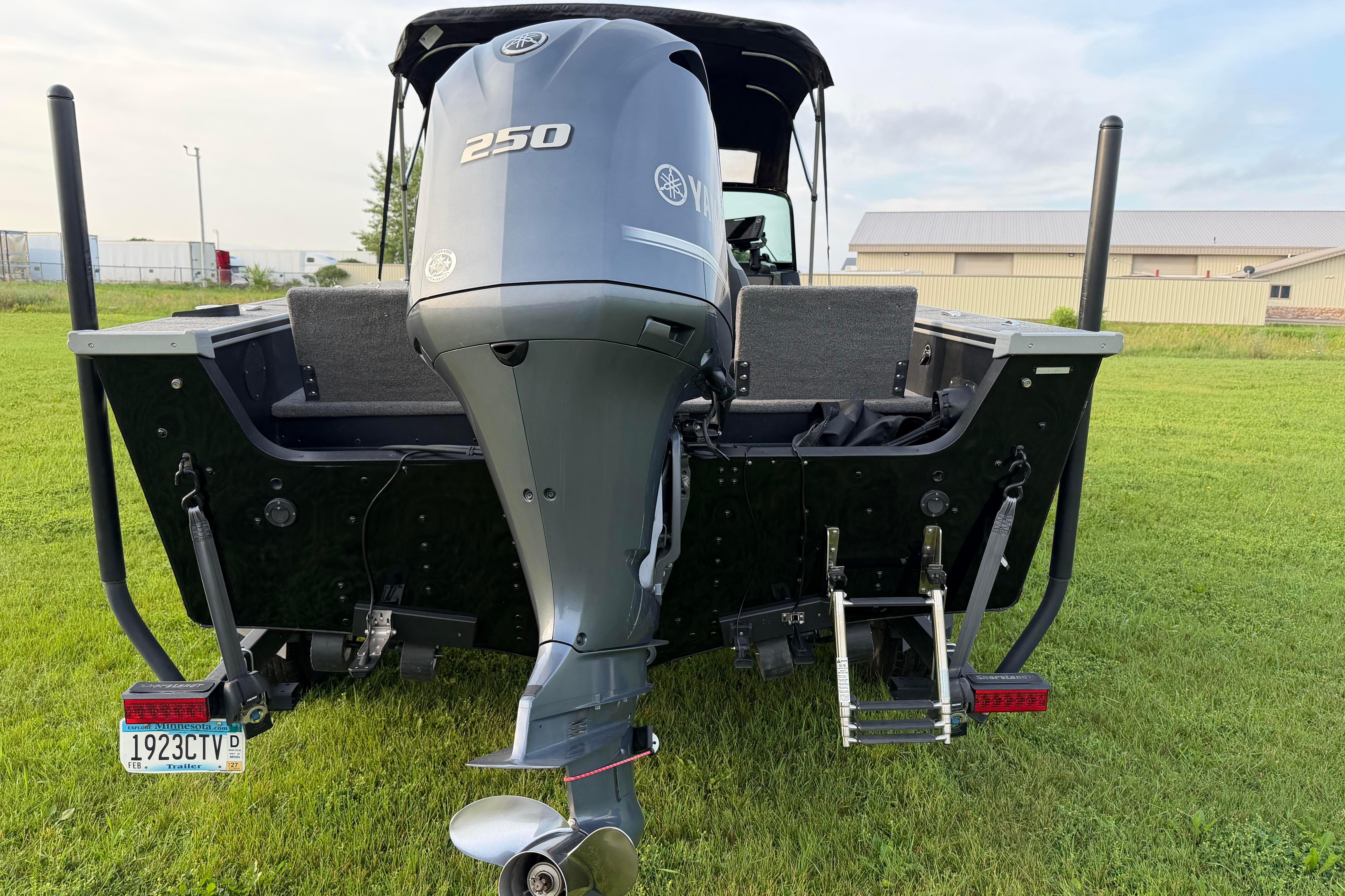 2019 Alumacraft Trophy 205 boat with Yamaha 250 outboard motor on grassy field.