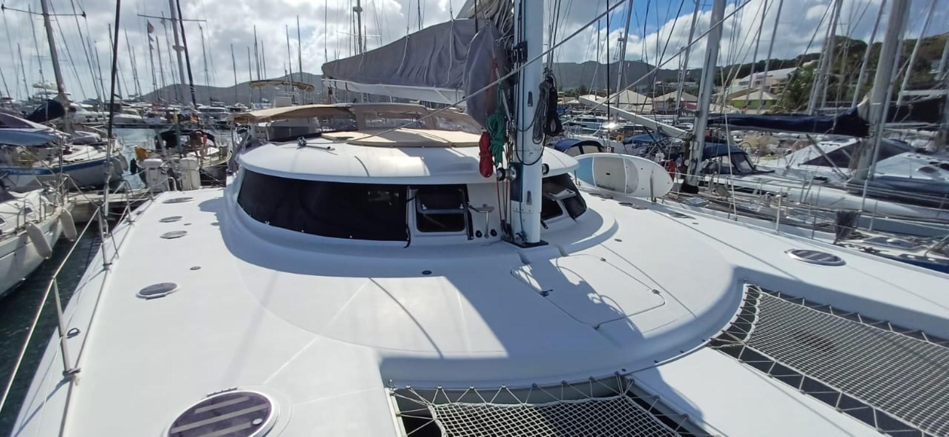 2008 Fountaine Pajot Eleuthera 60 catamaran docked in a marina, surrounded by other boats.