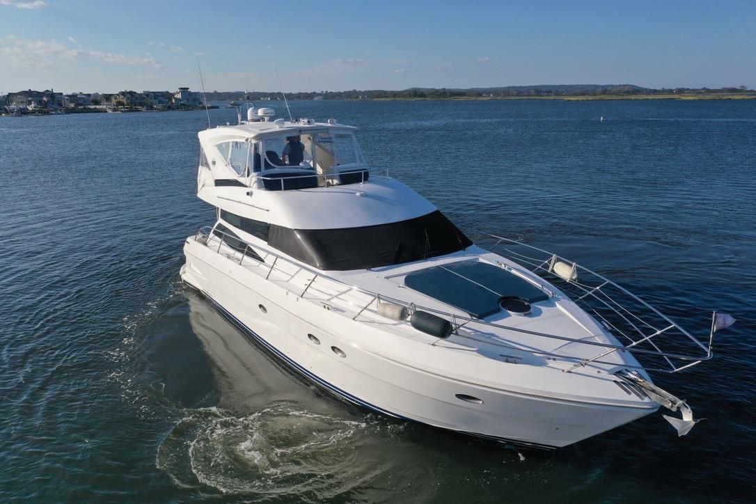 2005 Neptunus 56 Flybridge yacht cruising on calm waters.
