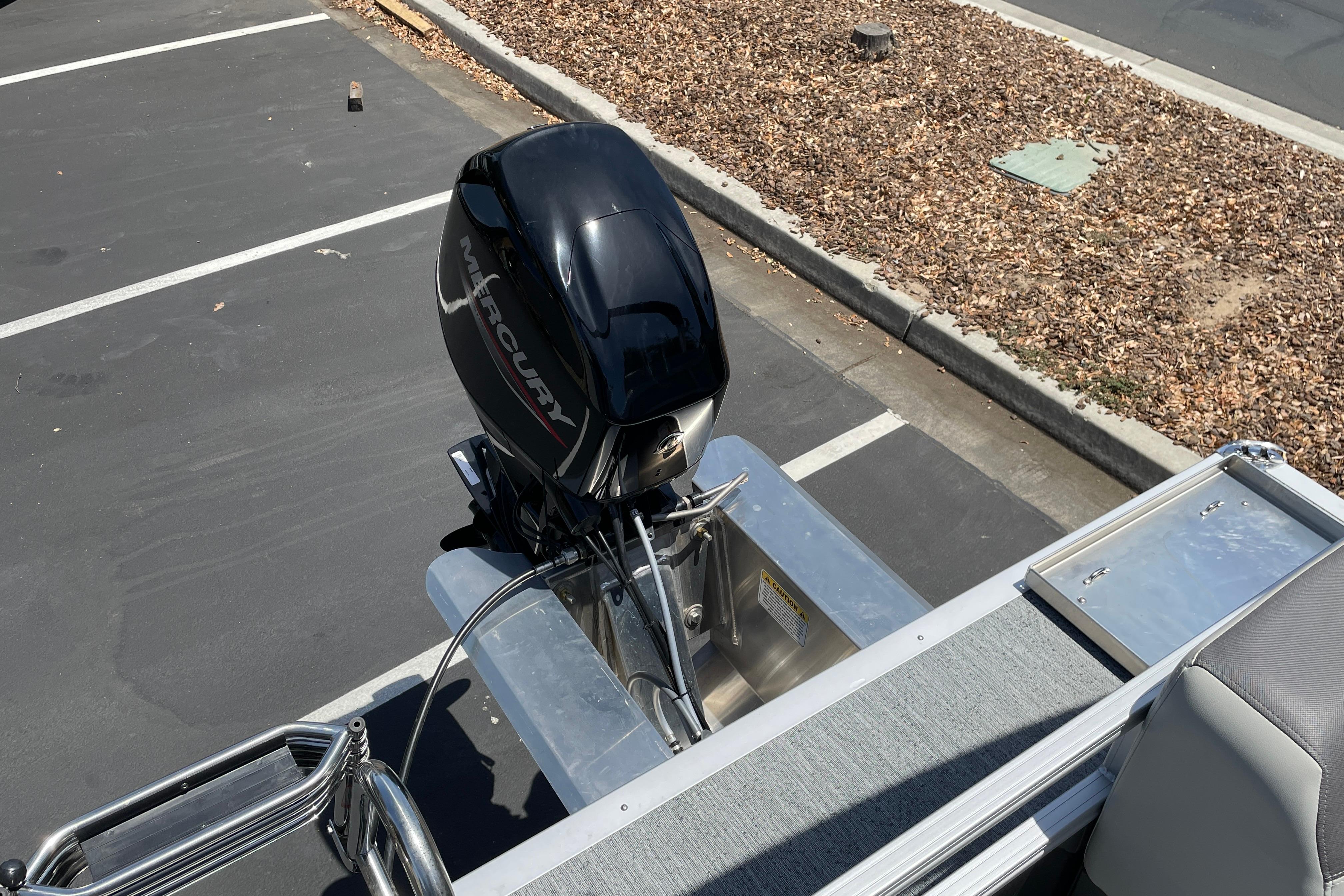 2026 Sun Tracker Bass Buggy 16 XL Select with Mercury outboard motor in parking lot.