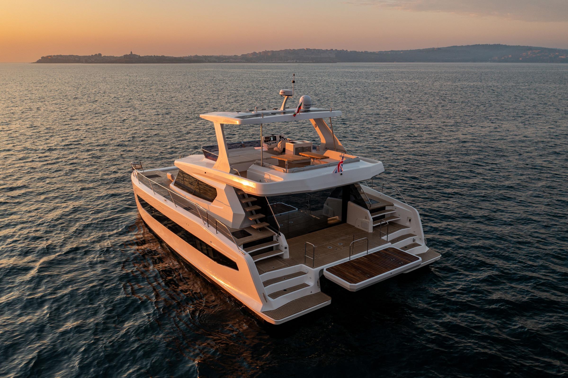 2025 Custom Omaya 50 Power Catamaran at sunset on calm waters.
