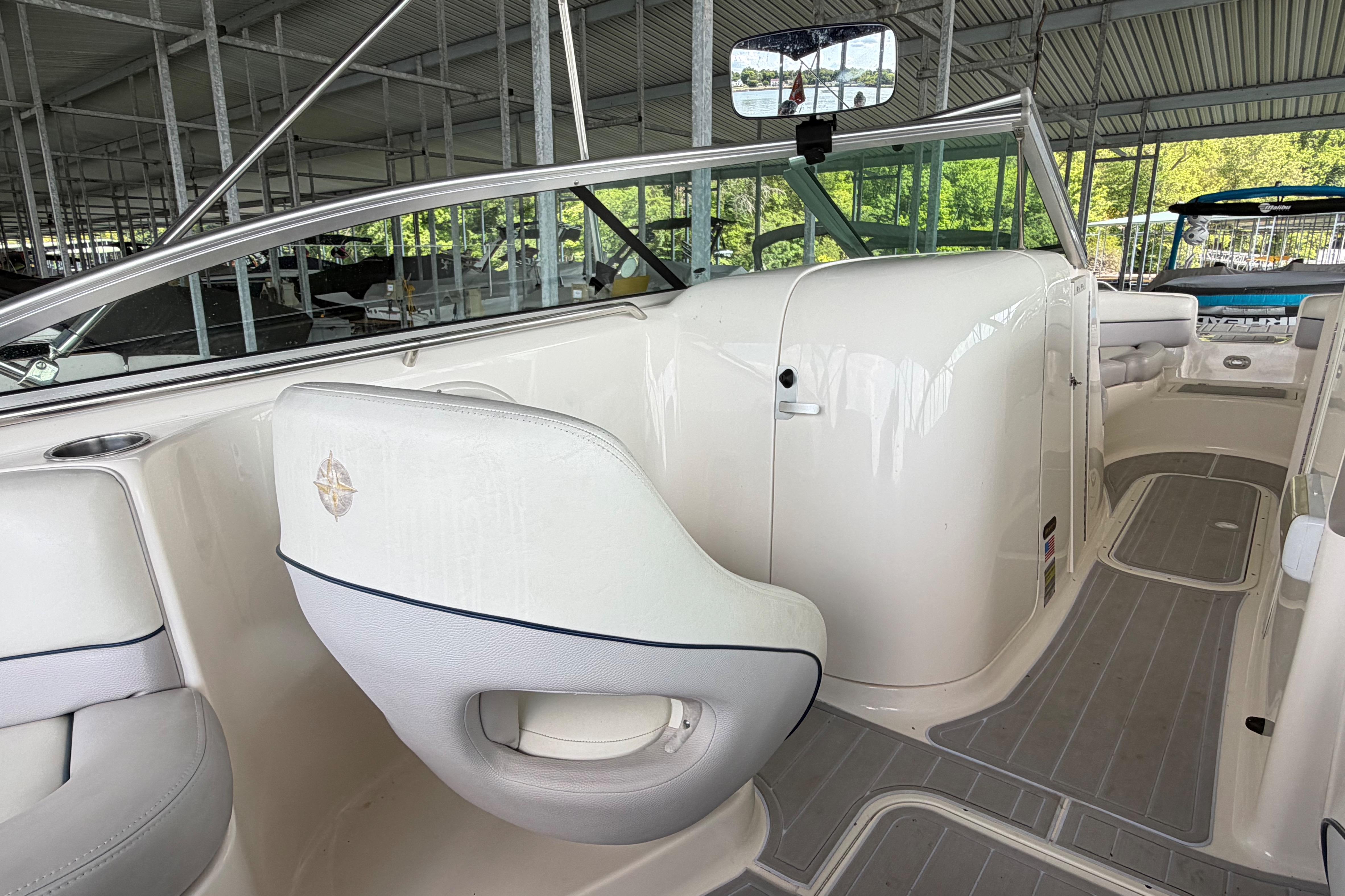2010 Bryant 255 boat interior with white seating and sleek design in a covered dock.