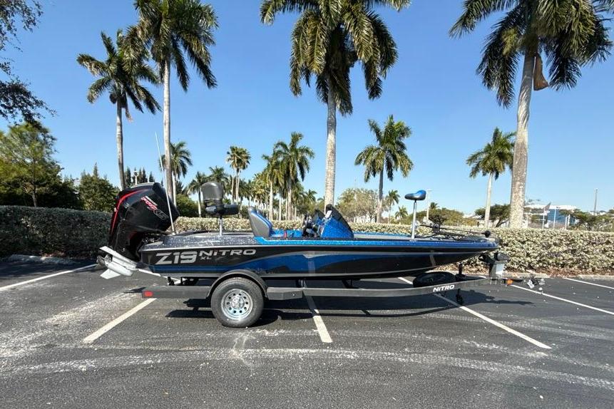 2026 Nitro Z19 XL boat parked under palm trees in a sunny lot.