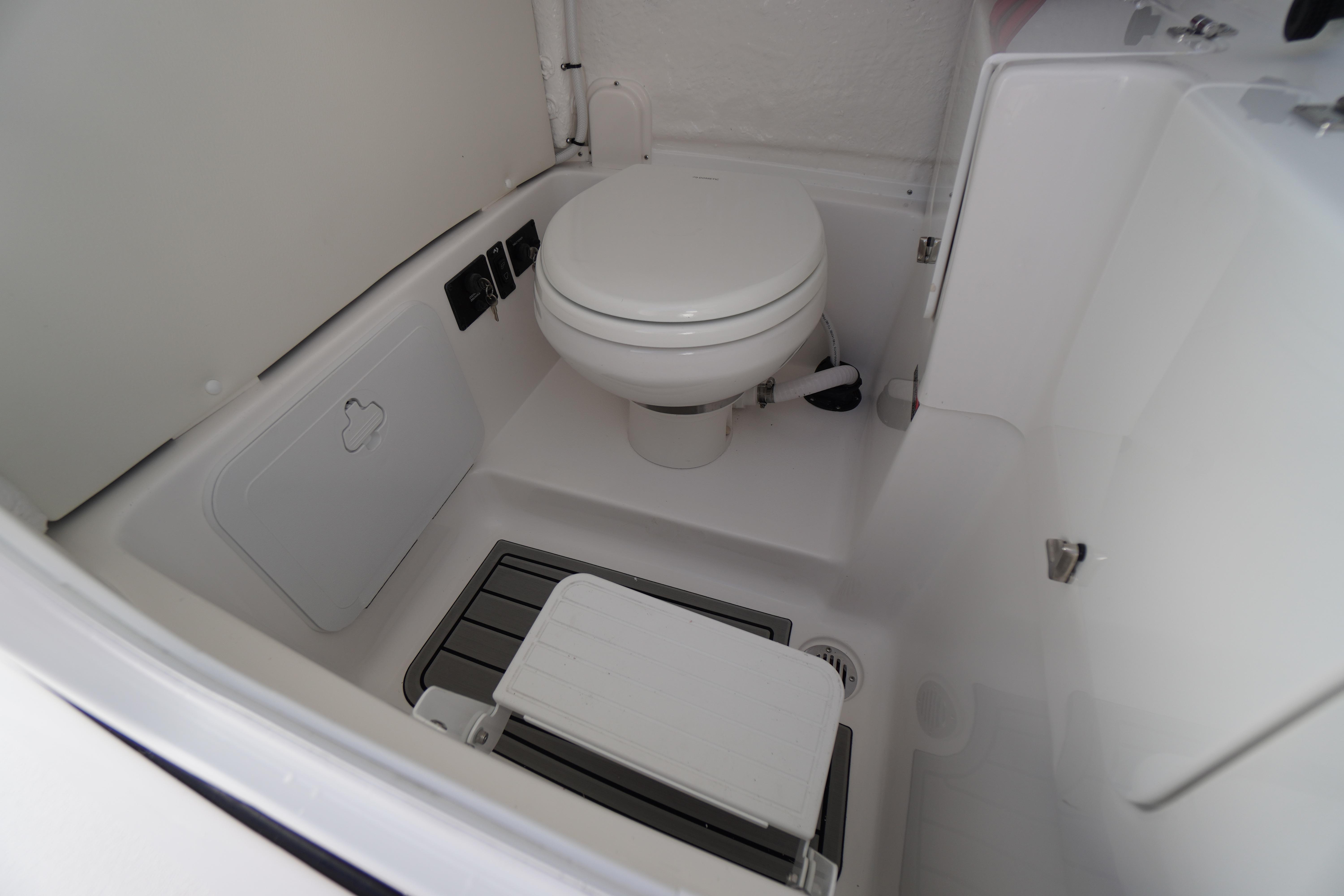 2026 Tidewater 272 LXF boat interior bathroom with toilet and compact design.