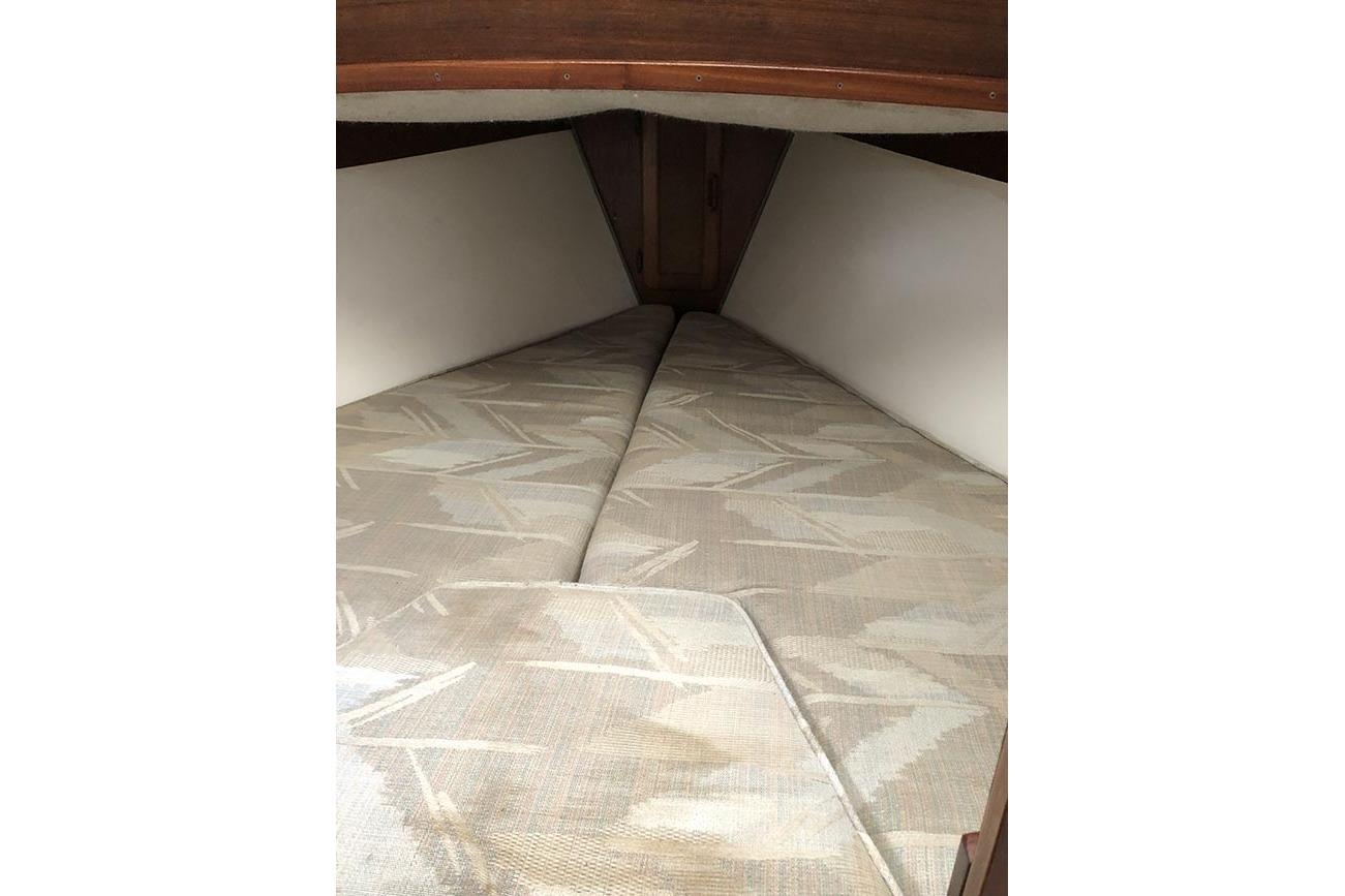 Interior cabin view of a 1995 Com-Pac 25 sailboat with patterned cushions.