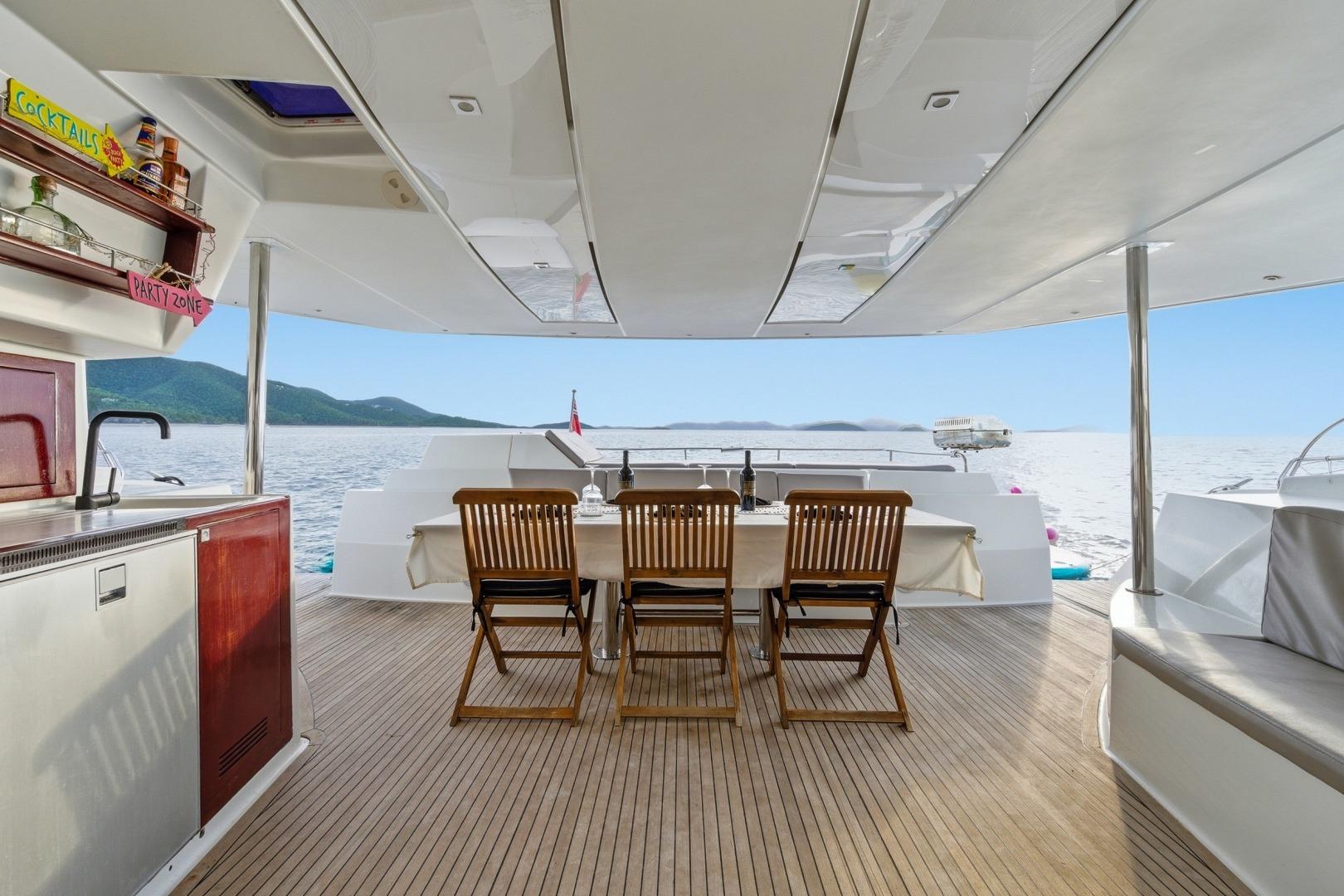 Luxurious 2013 Fountaine Pajot Sanya 57 yacht deck with dining area and ocean view.