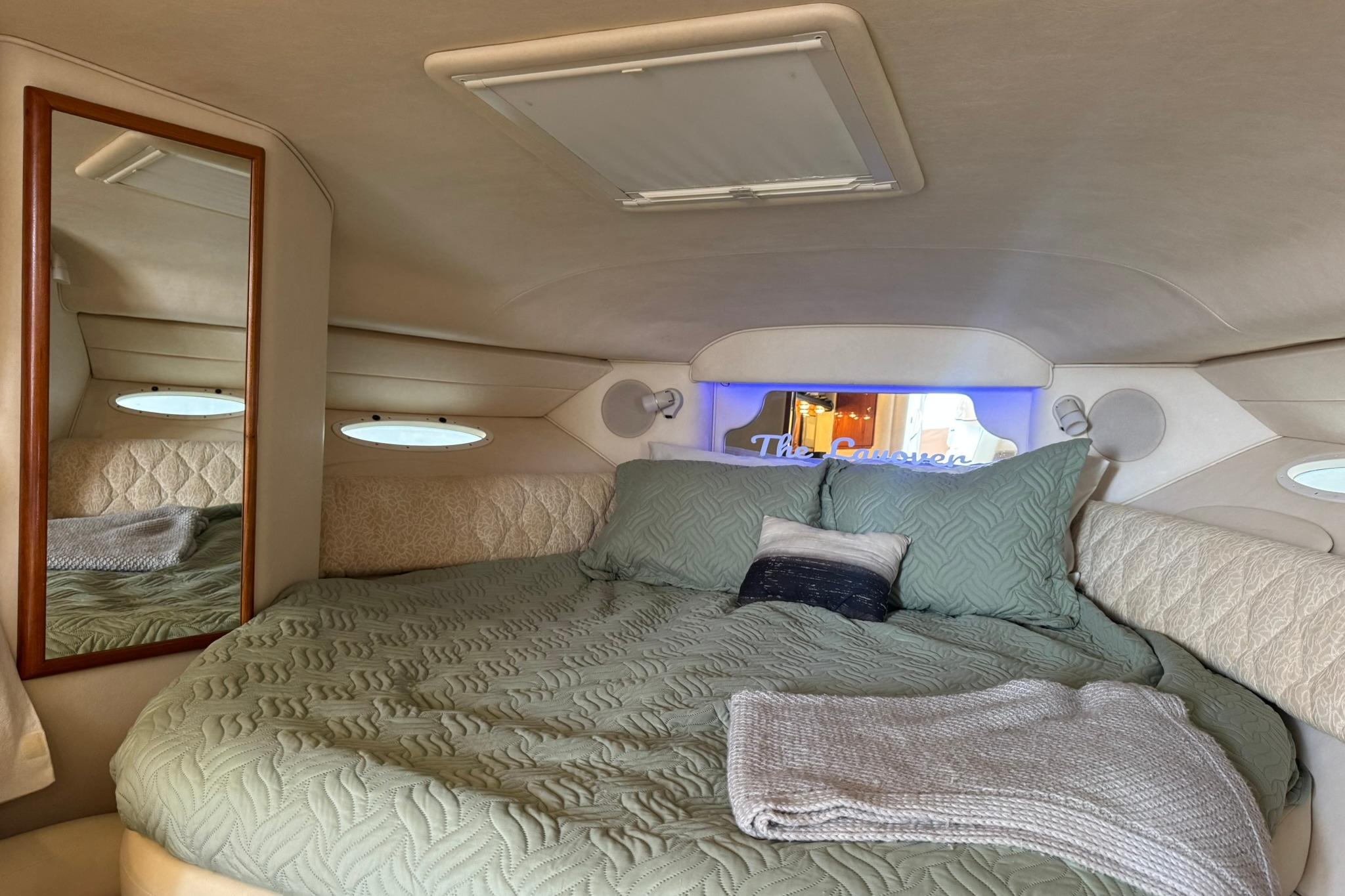 Cozy cabin interior of 2001 Sea Ray 340 Sundancer with bed and mirror.