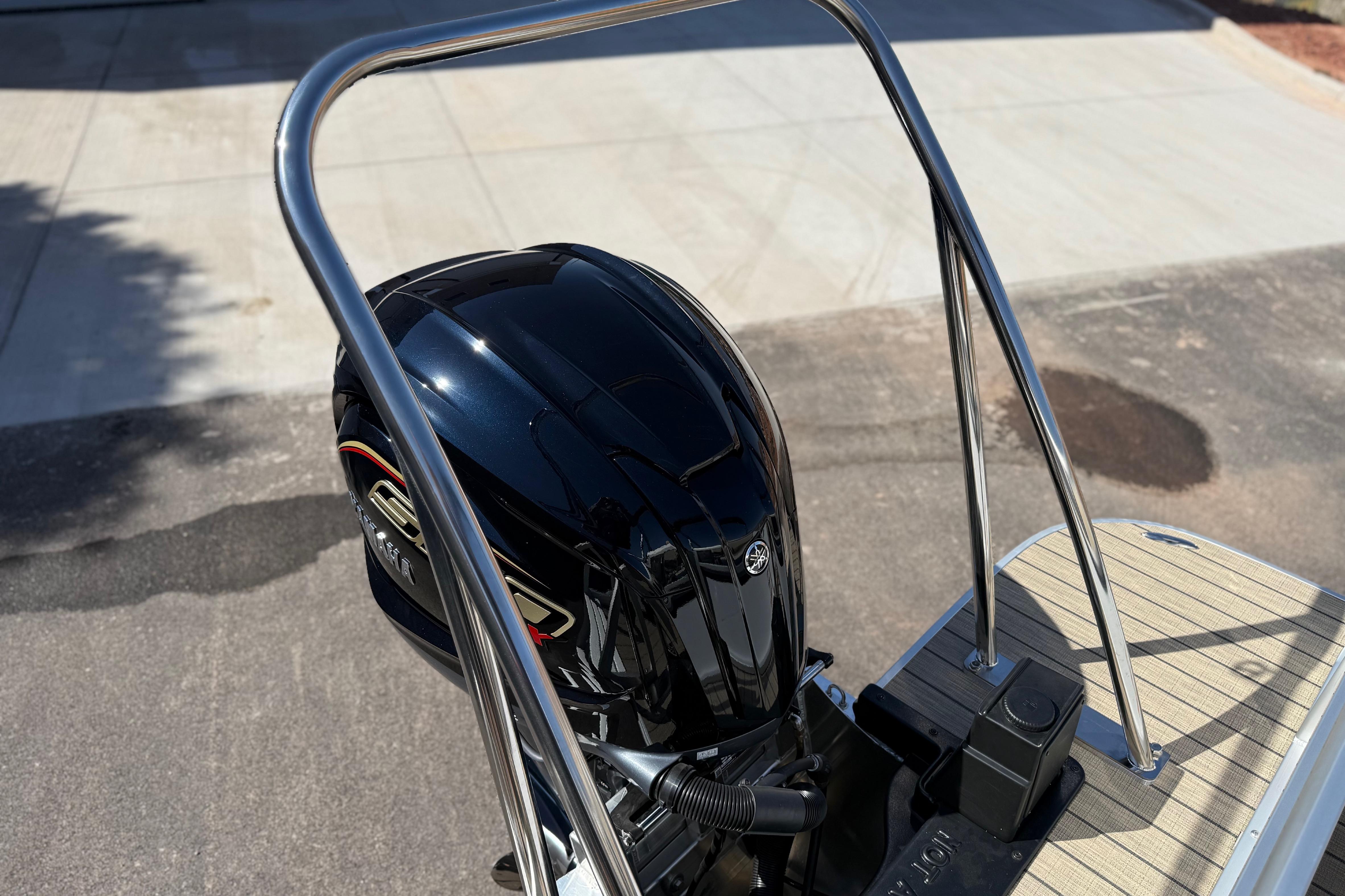Outboard motor on 2026 SunCatcher Select 322SL boat, docked on a sunny day.