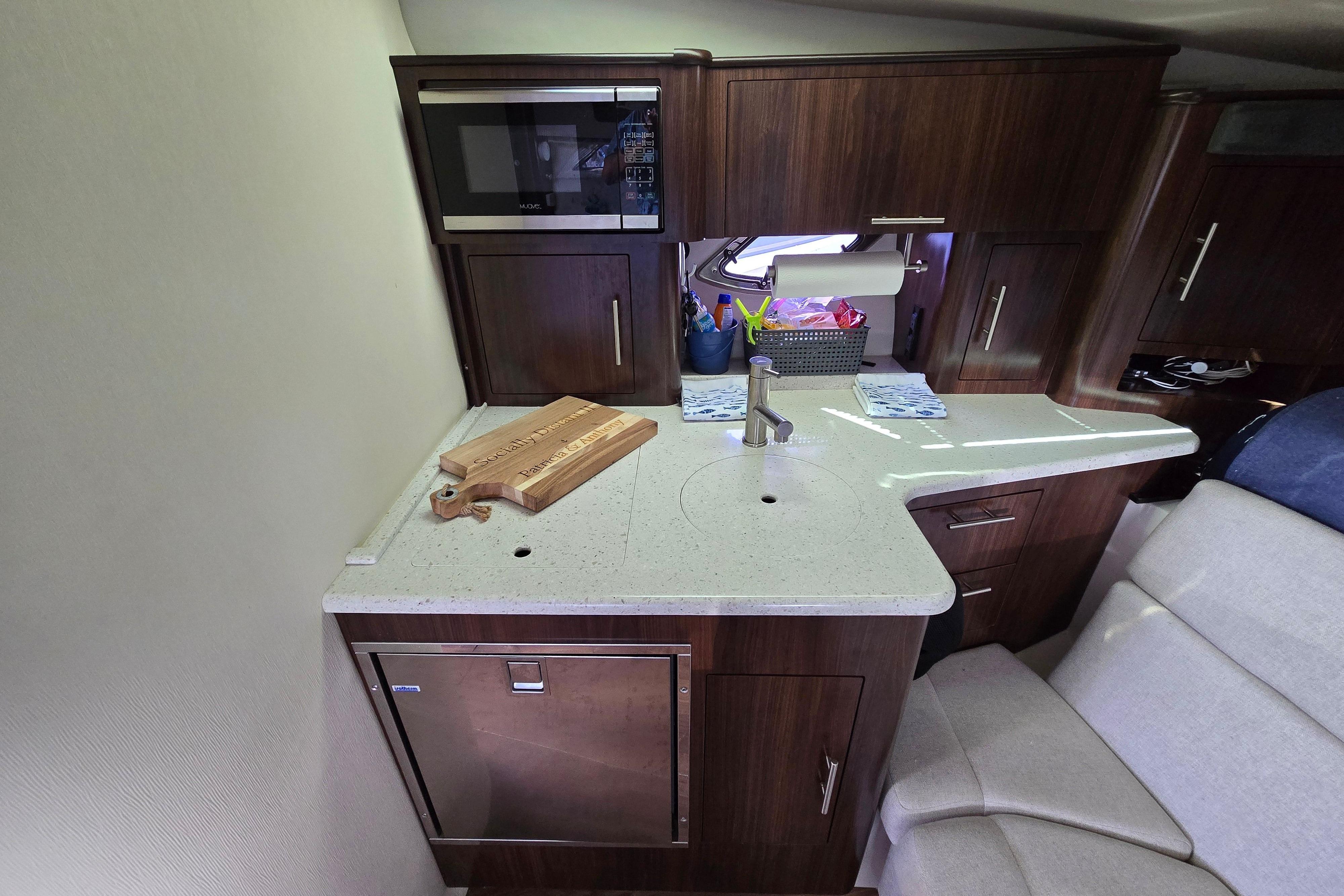 2018 Regal 35 Sport Coupe interior kitchen with modern appliances and wooden cabinetry.