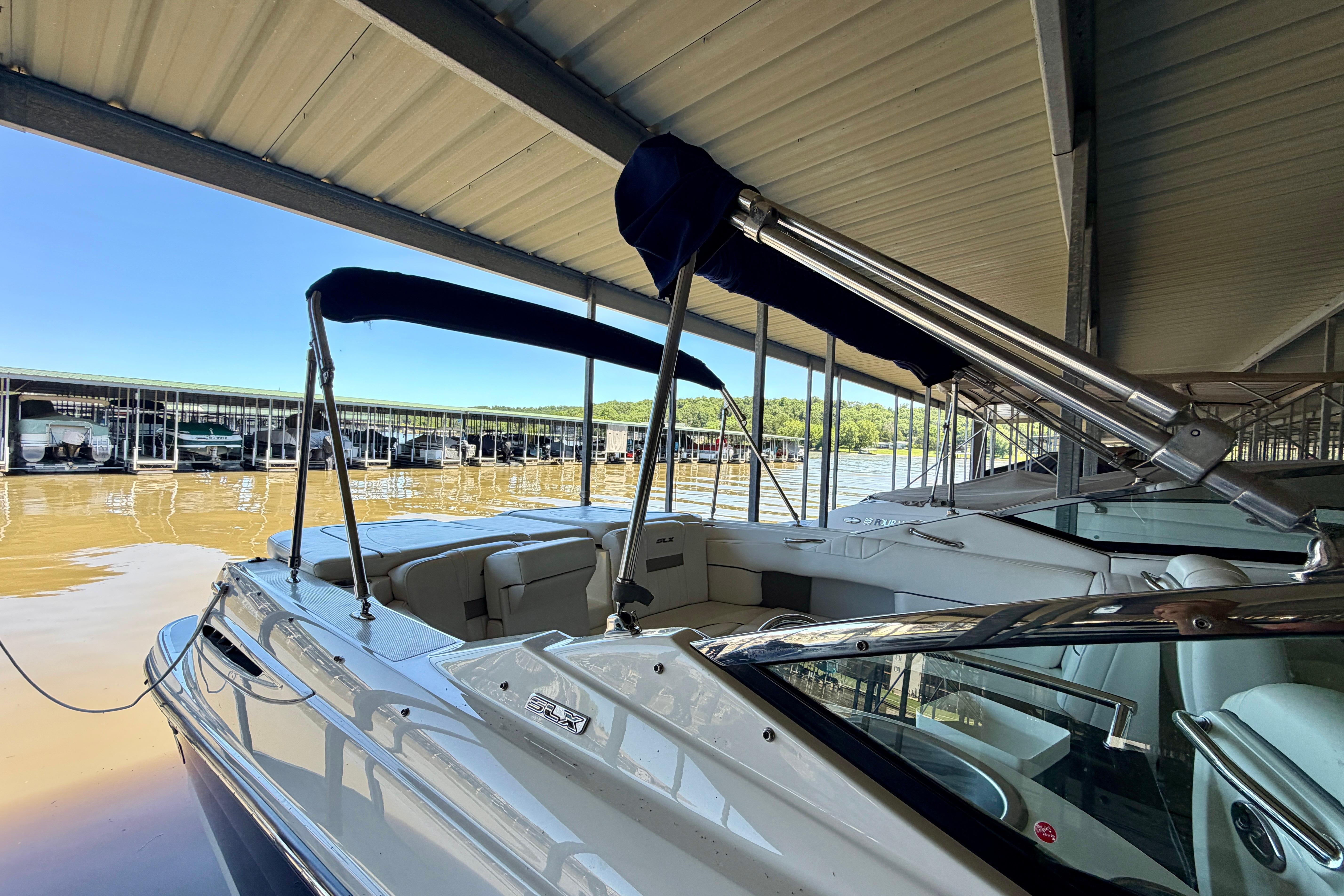 2007 Sea Ray 270 SLX boat docked under a covered marina.