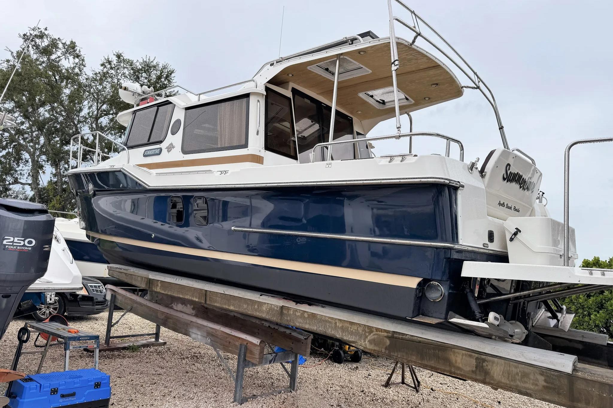 2015 Ranger Tugs R-29 S boat on trailer, blue and white exterior, parked outdoors.