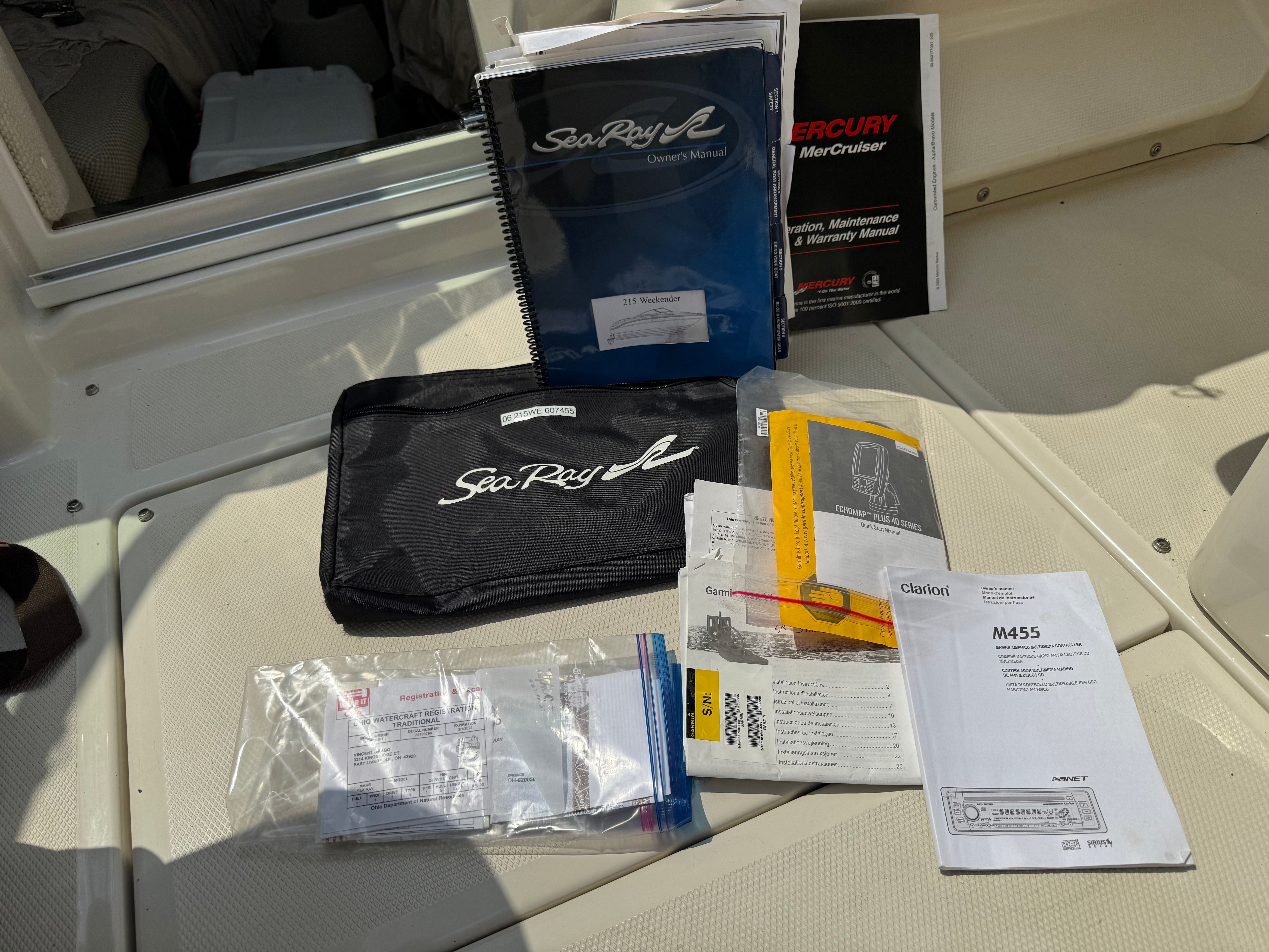Sea Ray 215 Weekender manuals and documents on boat seat.