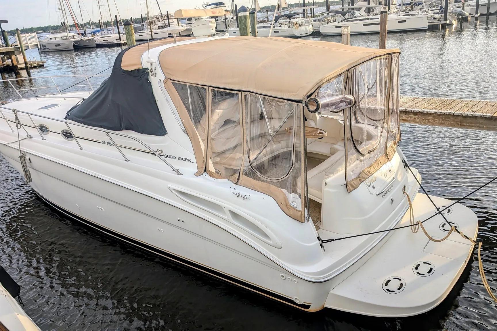 2000 Sea Ray 380 Sundancer yacht docked at marina, featuring beige canopy and sleek design.