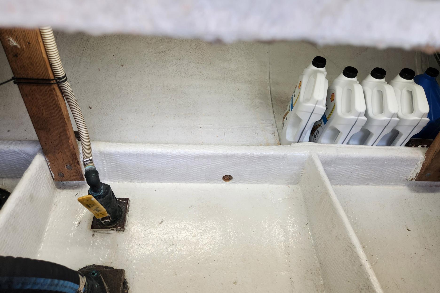 Bilge area of 1987 Young Brothers Custom Sport Fish with oil containers.