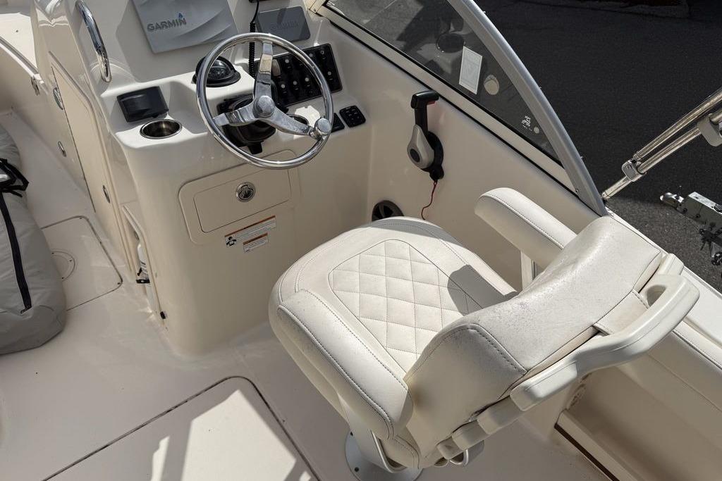 2019 Grady-White Freedom 215 boat cockpit with steering wheel and cushioned seat.