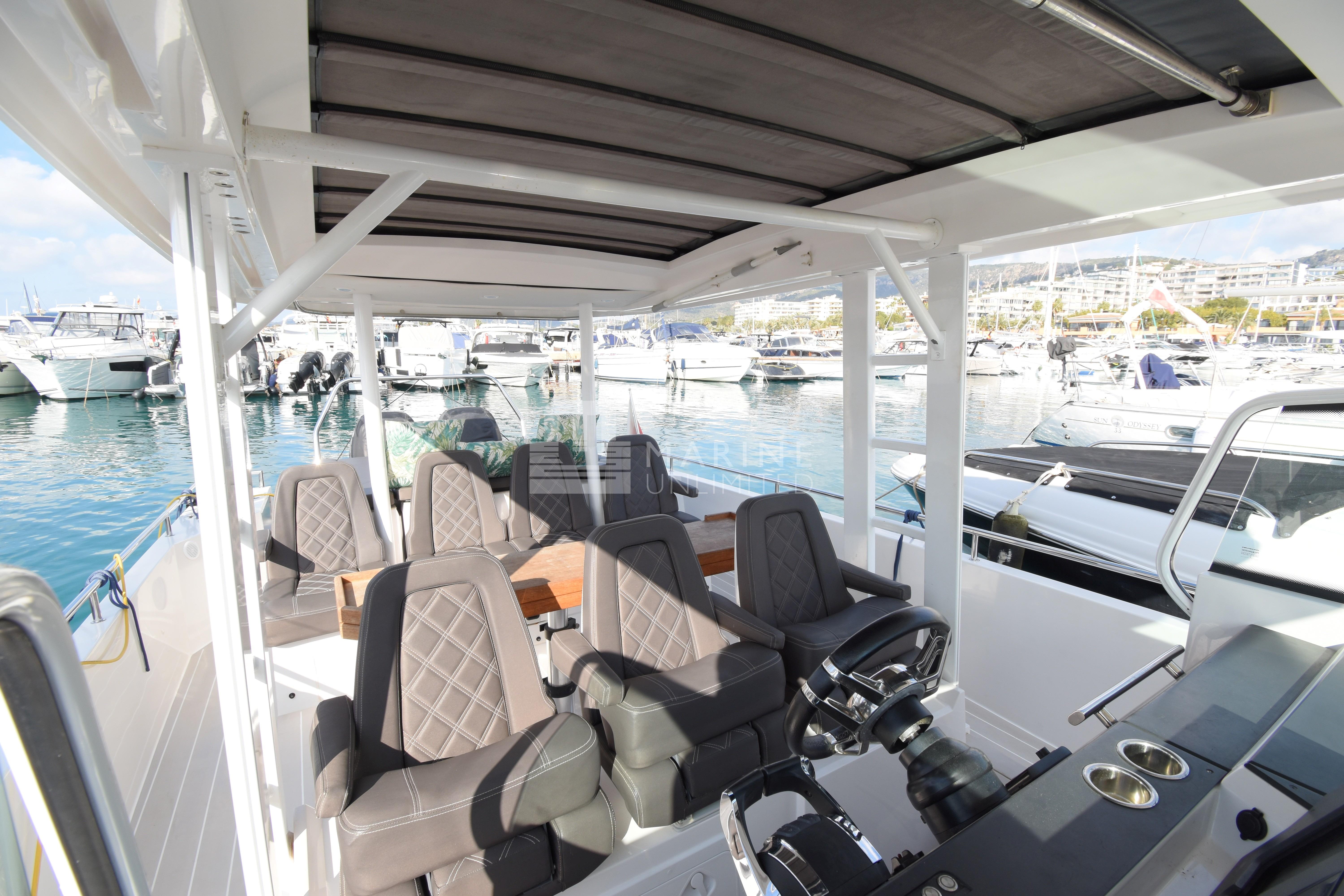 2016 Axopar 37 Sun-Top boat interior with seating, docked in a marina.