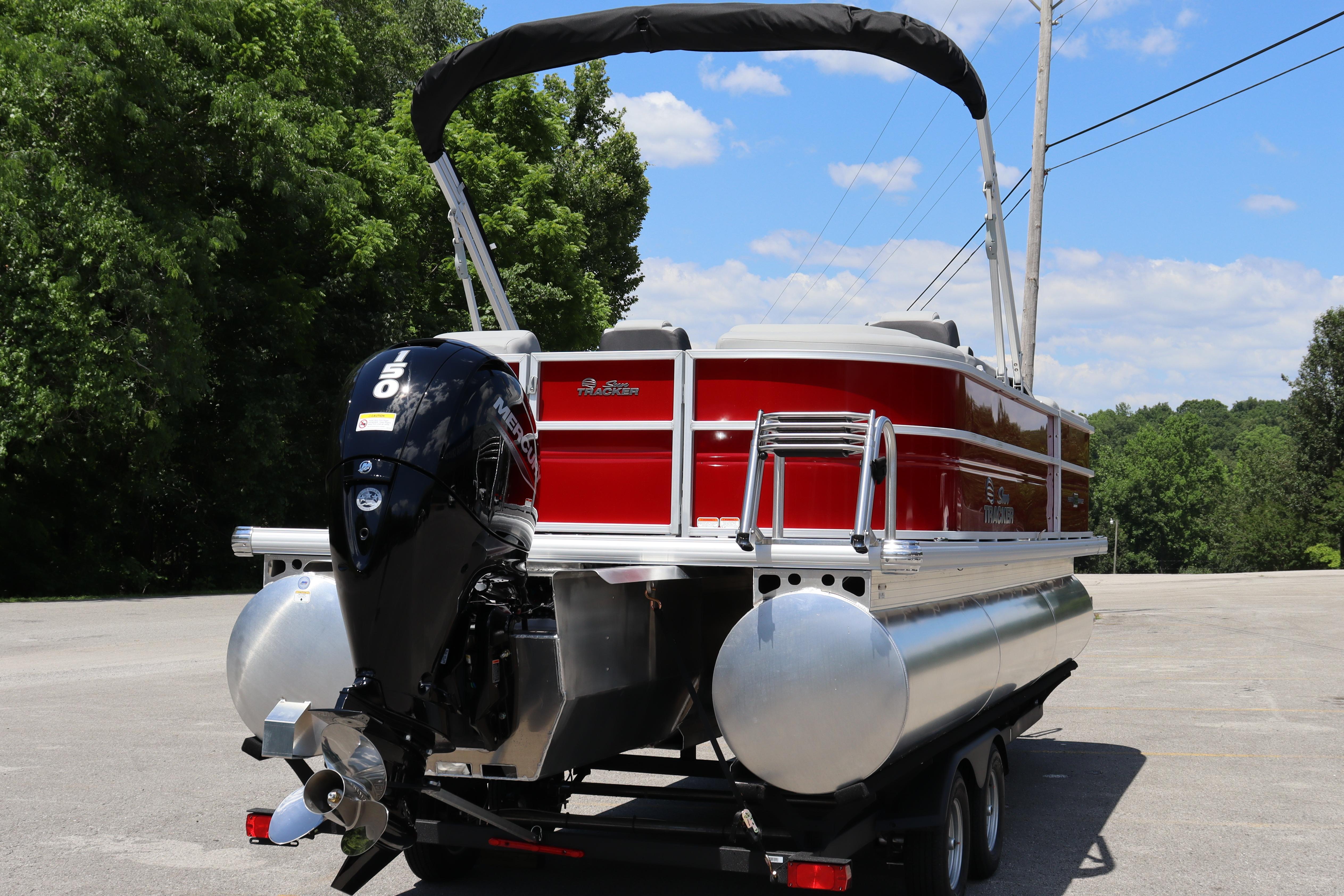 2026 Sun Tracker Party Barge 22 XP3 pontoon boat with outboard motor, parked outdoors.