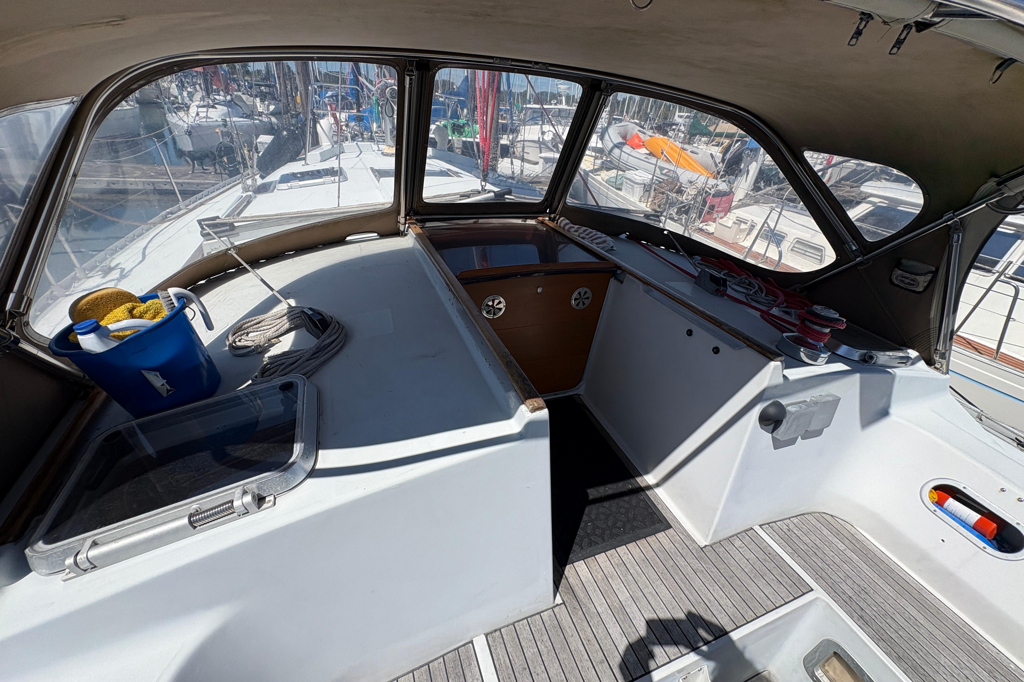 Cockpit of 1990 Beneteau Oceanis 500 sailboat with cleaning supplies and ropes.