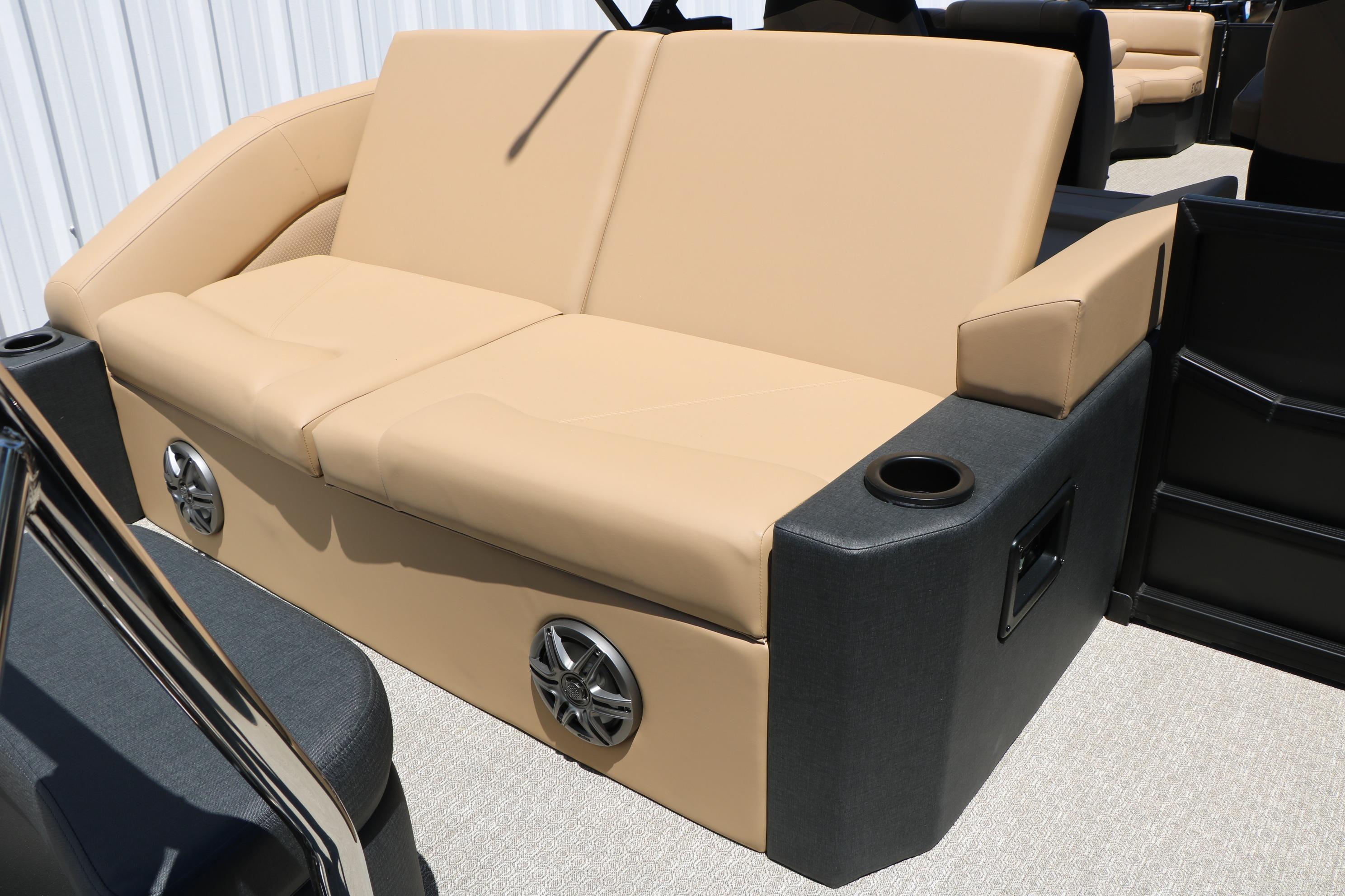 Luxurious beige seating on 2026 Evotti 521CS boat, featuring built-in speakers and cup holders.