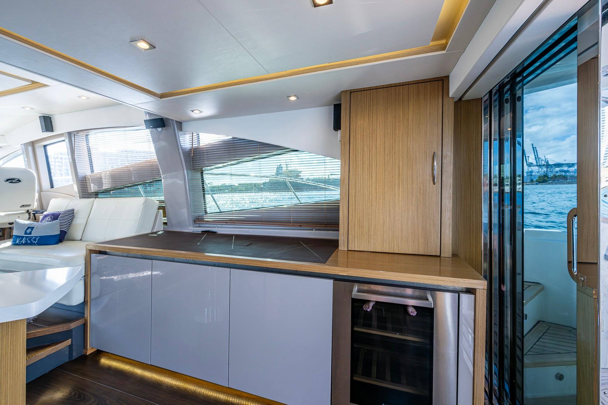 Luxurious interior of 2018 Sea Ray L550 Fly yacht with modern cabinetry and scenic water view.