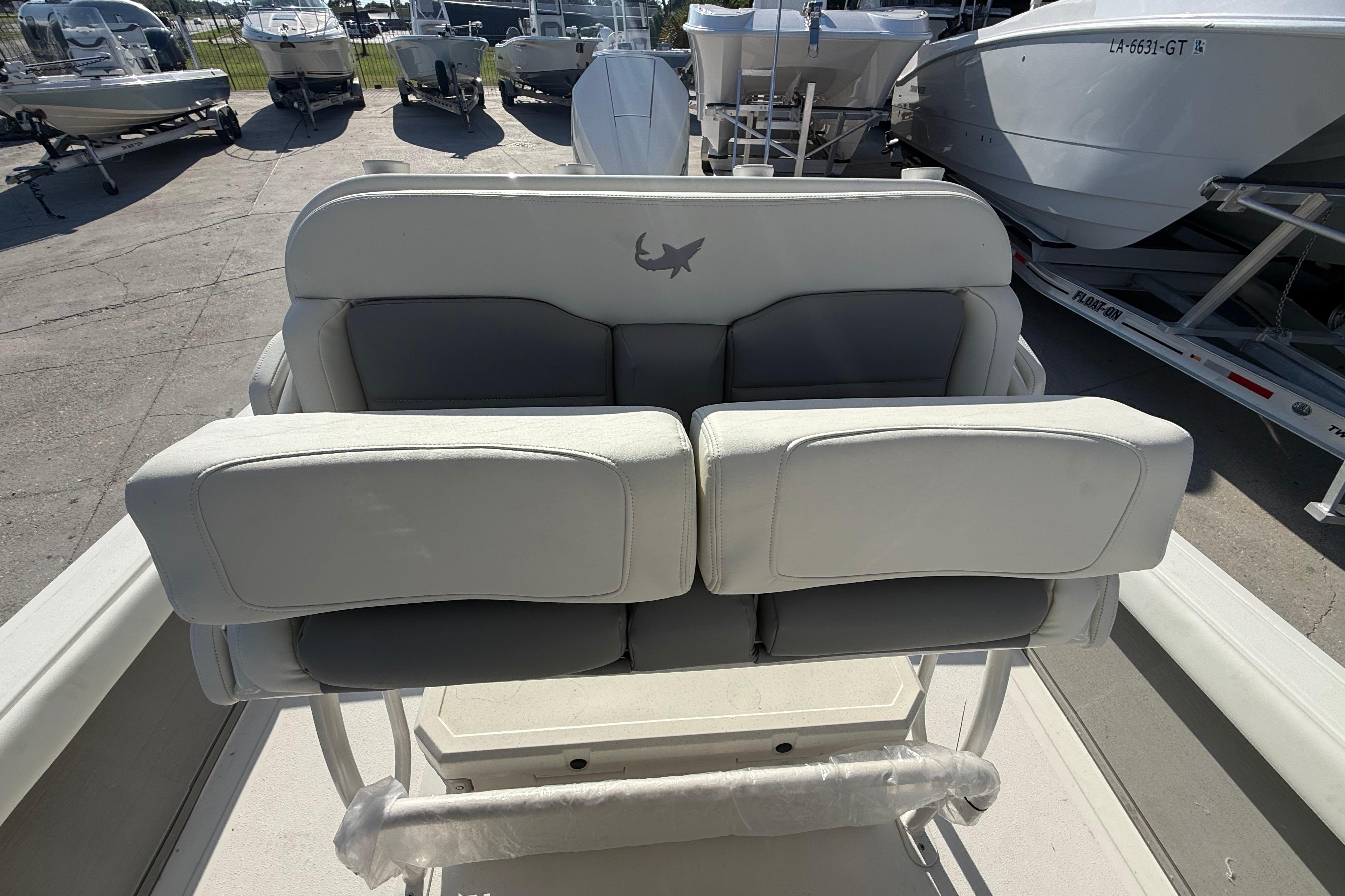 2026 Mako 24 APEX boat seating, featuring cushioned dual seats in a marina setting.