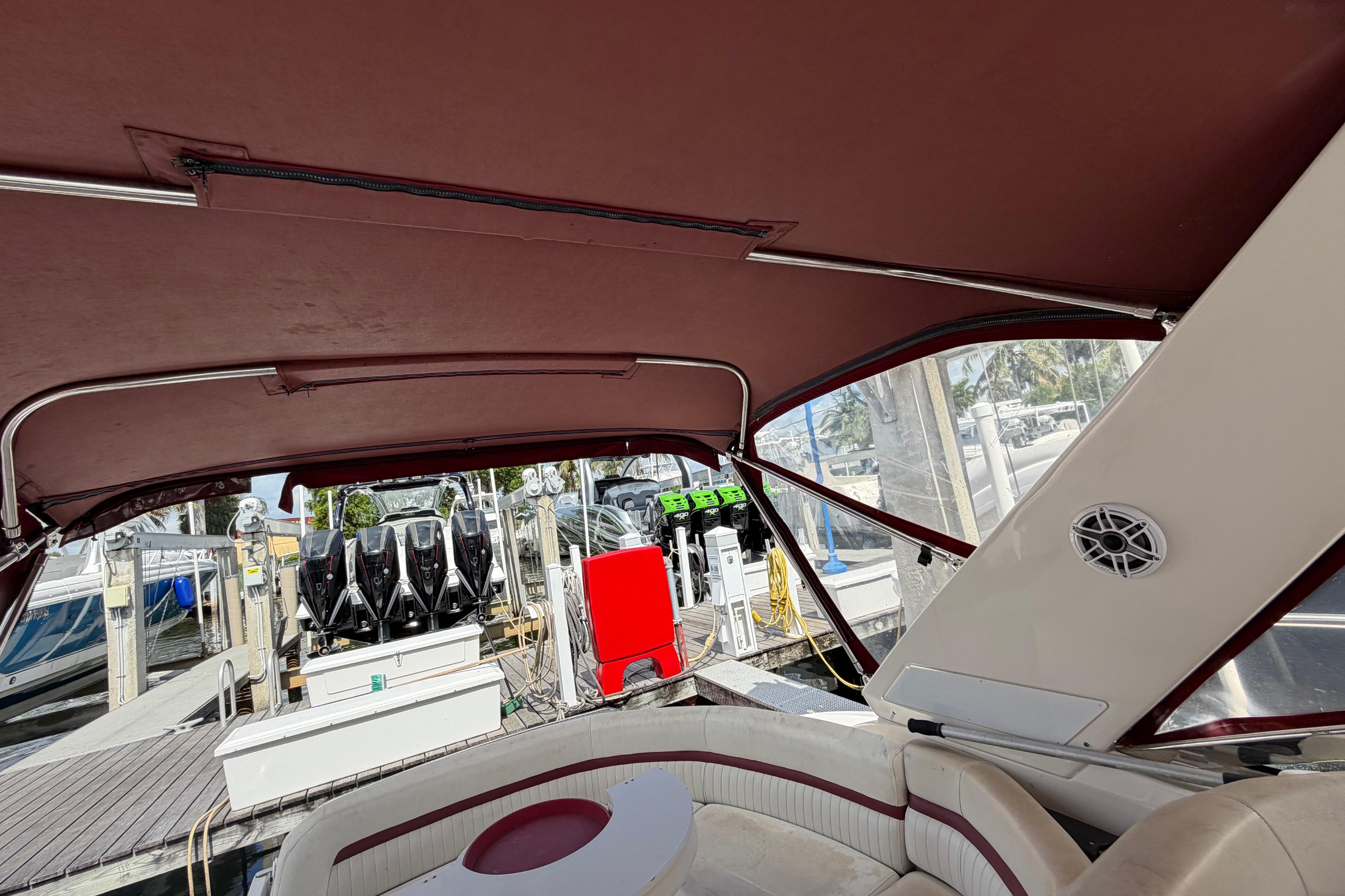 Interior view of a 2007 Monterey 350 Sport Yacht with maroon canopy at a marina.