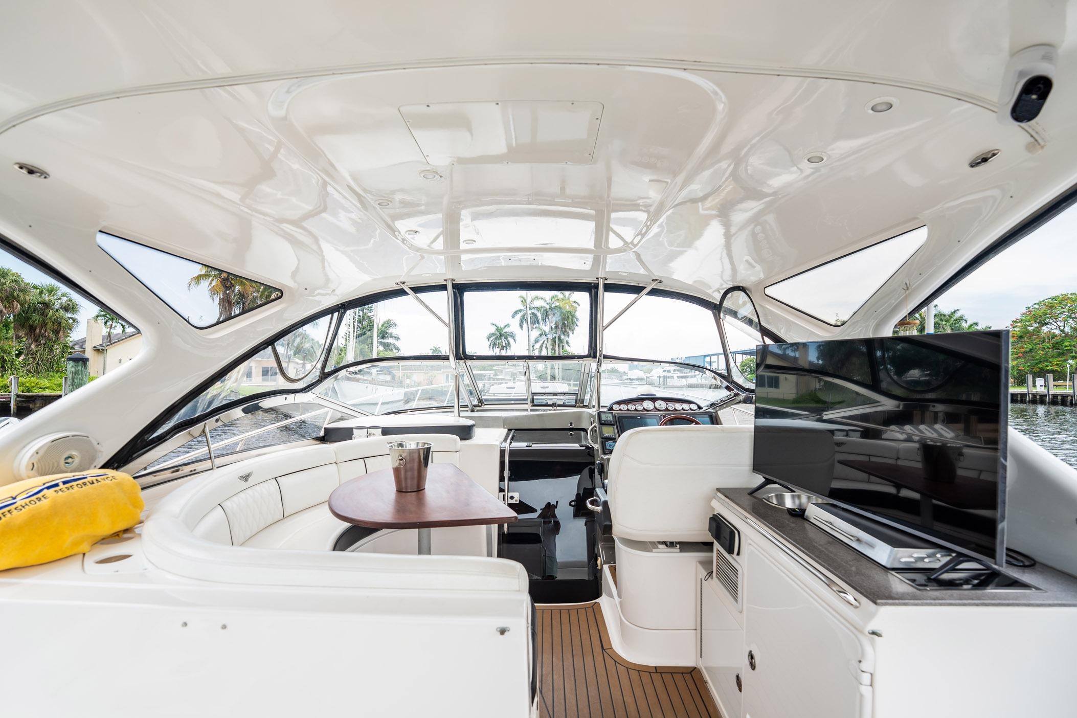 Luxurious 2008 Regal Commodore 4460 yacht interior with seating, table, and TV.