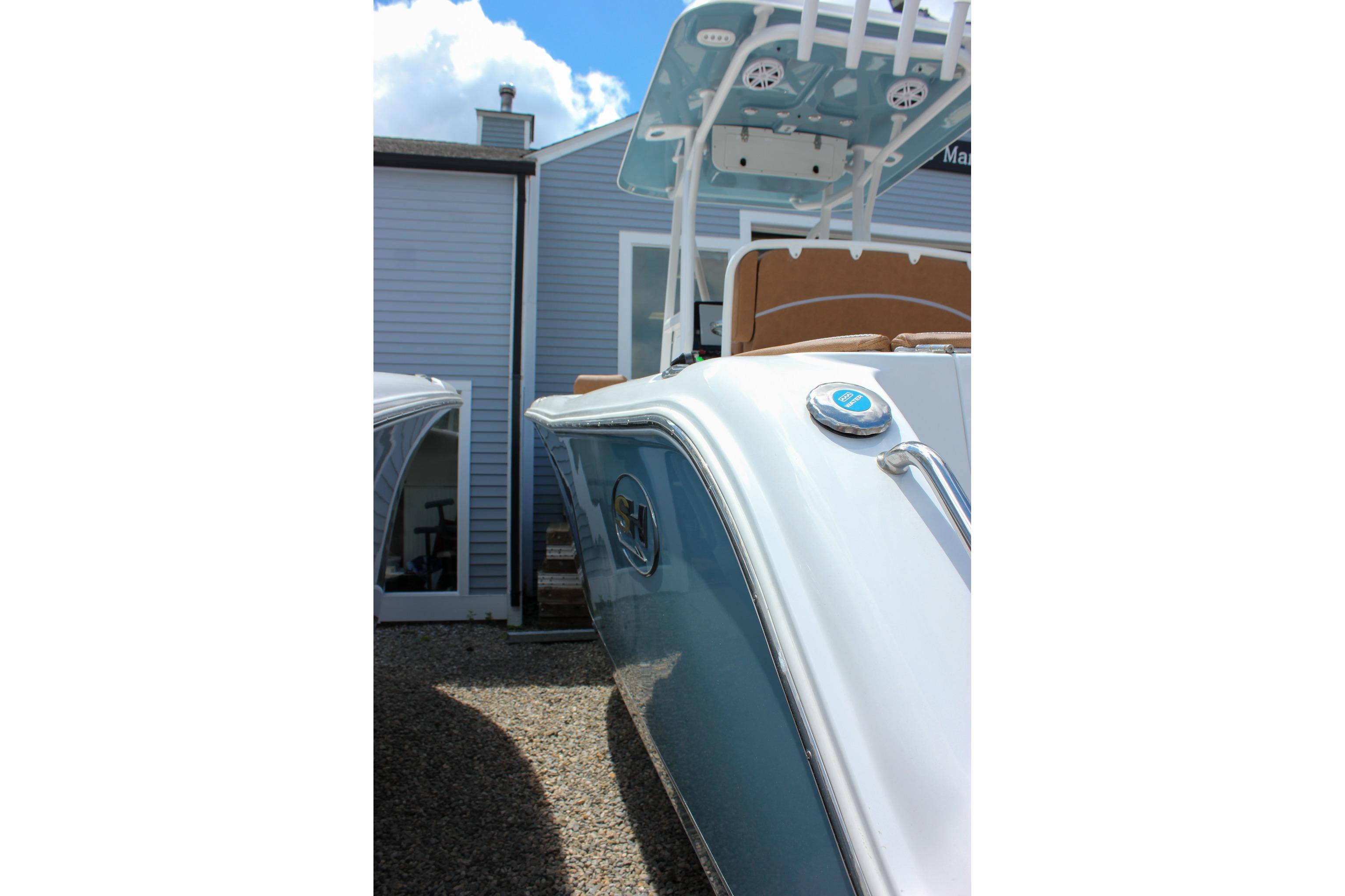 2027 Sea Hunt Ultra 234 boat, sleek design, parked outdoors near a building.
