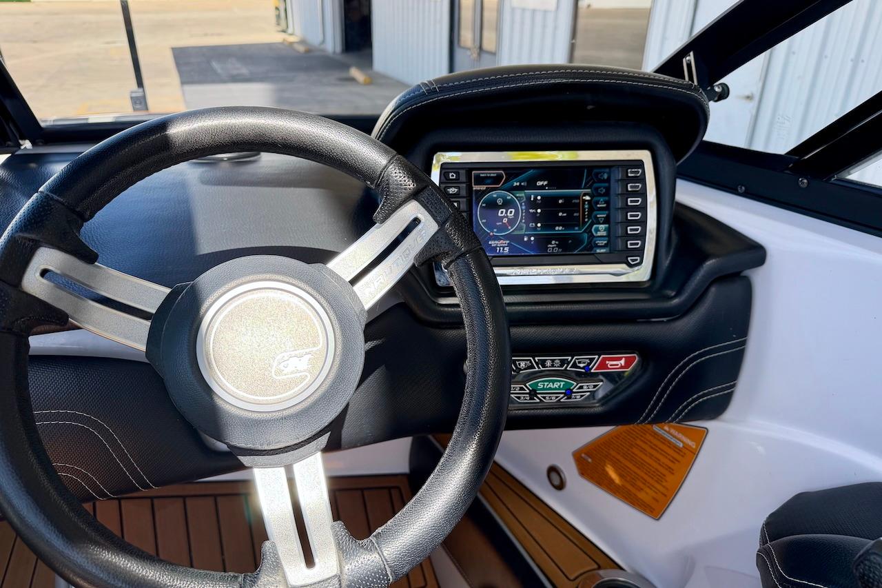 2014 Nautique Super Air Nautique G21 dashboard with steering wheel and digital display.