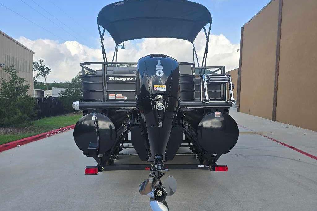 2026 Ranger 223FC boat with outboard motor, parked on a concrete driveway.