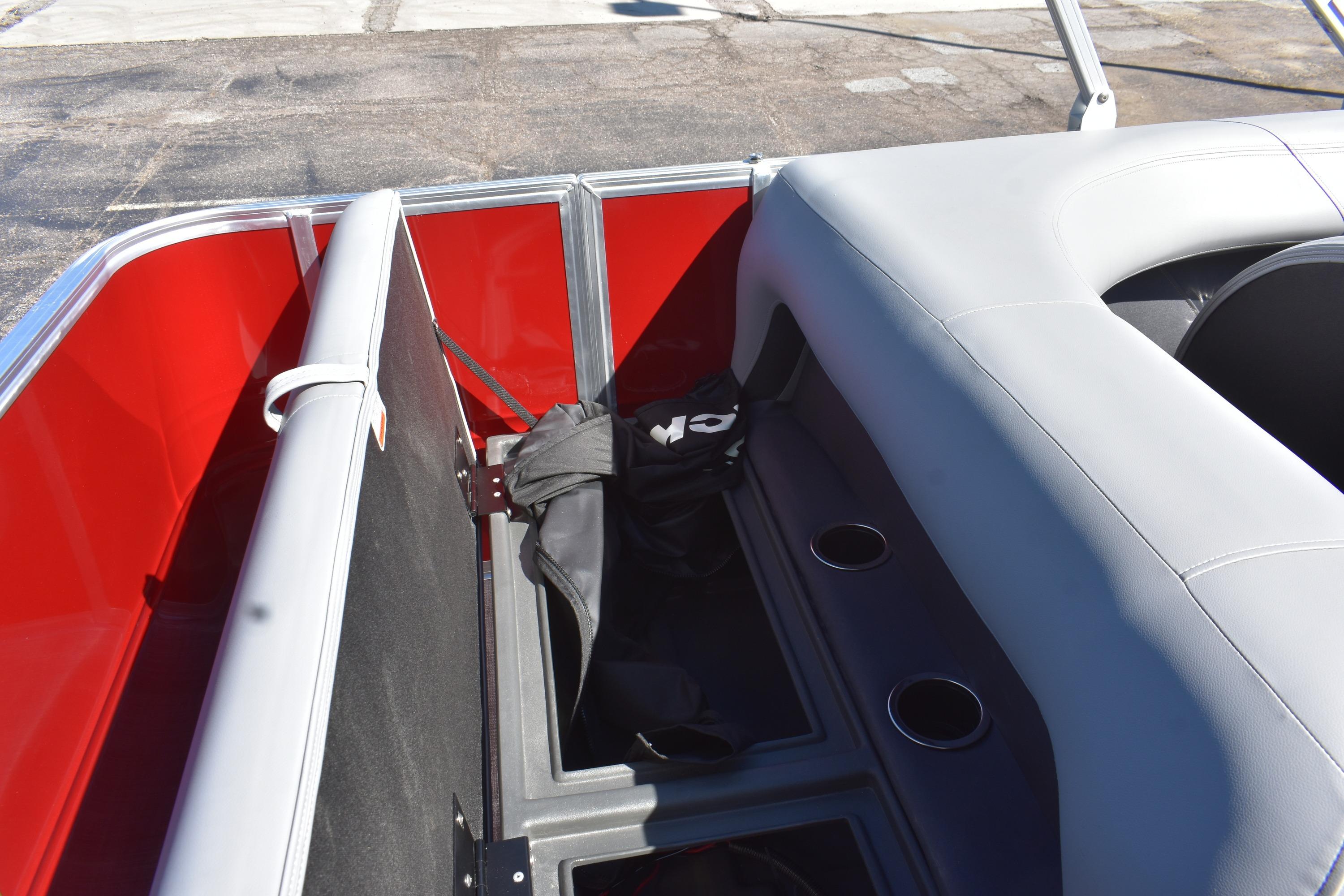 2026 Sun Tracker Party Barge 18 DLX interior with red accents and seating storage.