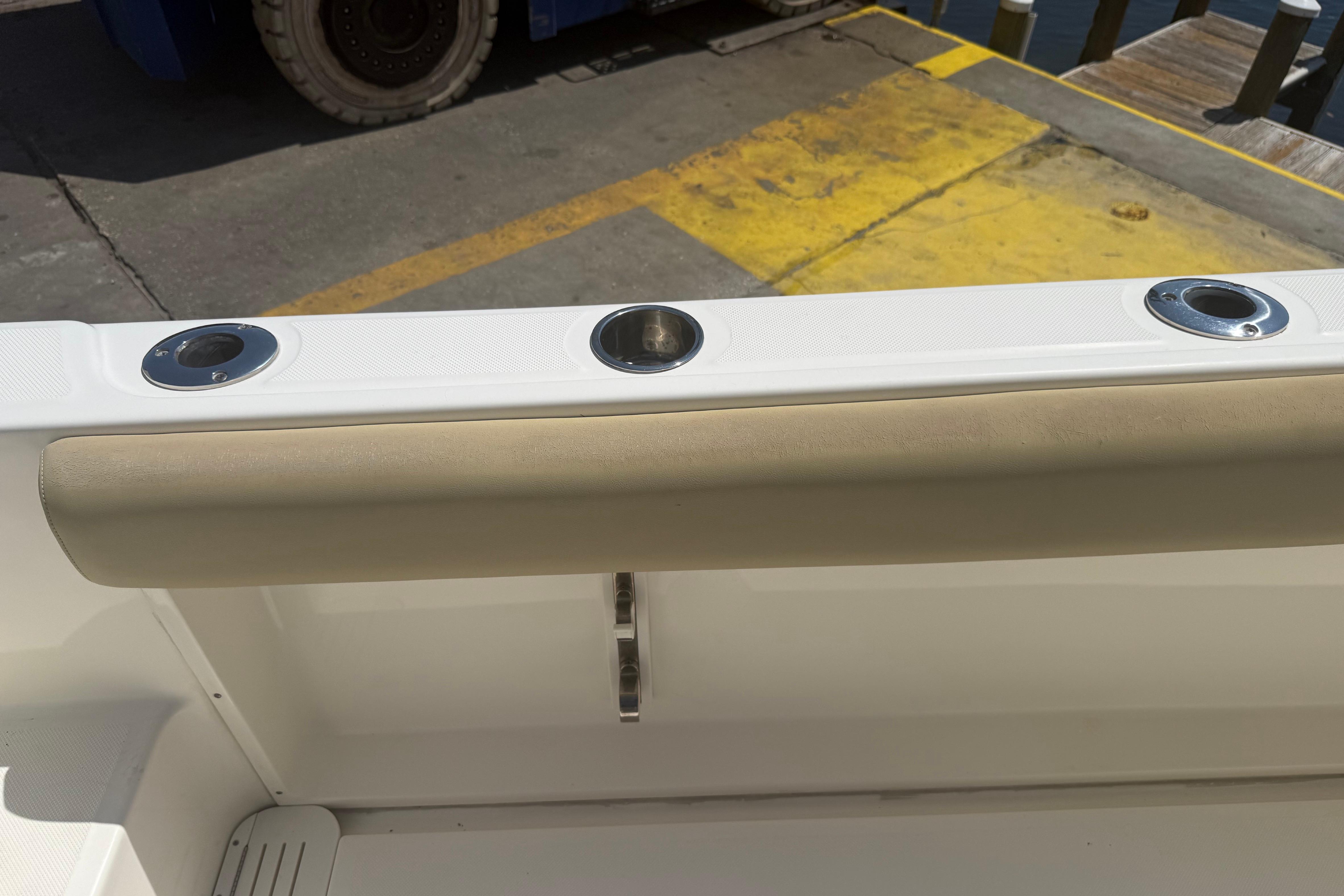 2019 Key West Billistic 281 Center Console boat interior with rod holders and cushioned rail.