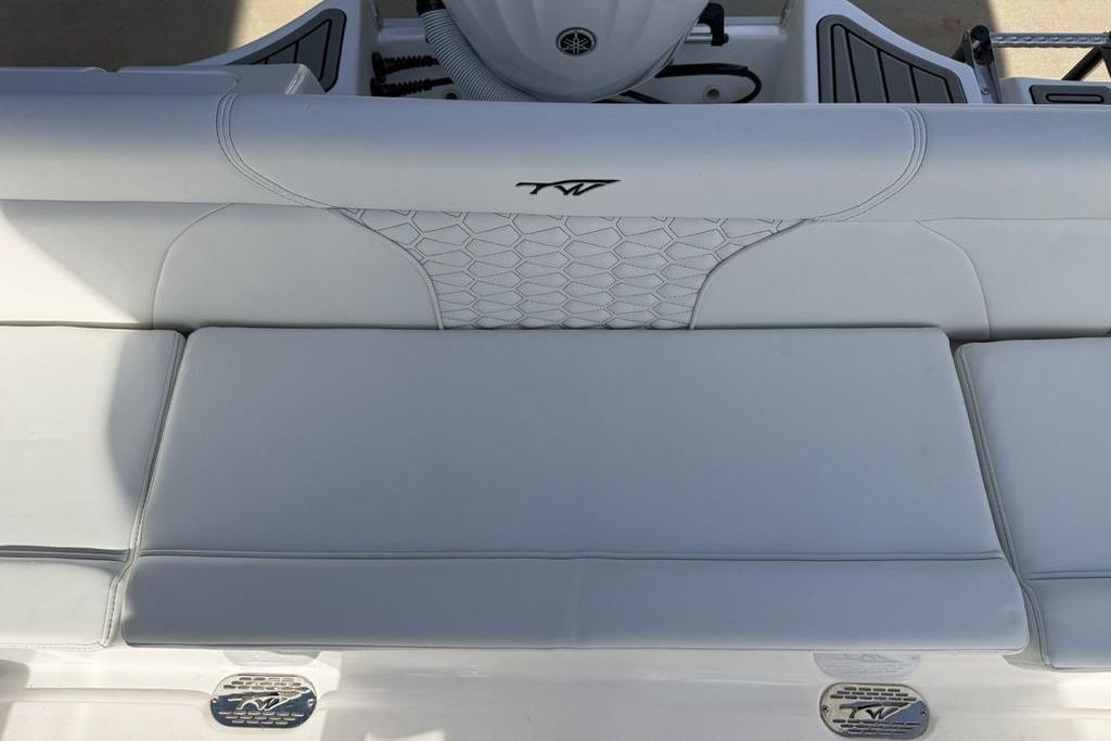 2026 Tidewater 232 LXF boat interior with white cushioned seating and logo detail.