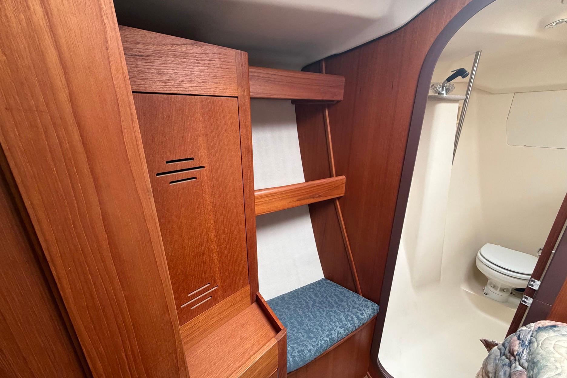 Interior of a 1998 Hunter 410 sailboat featuring wooden cabinetry and a compact bathroom.