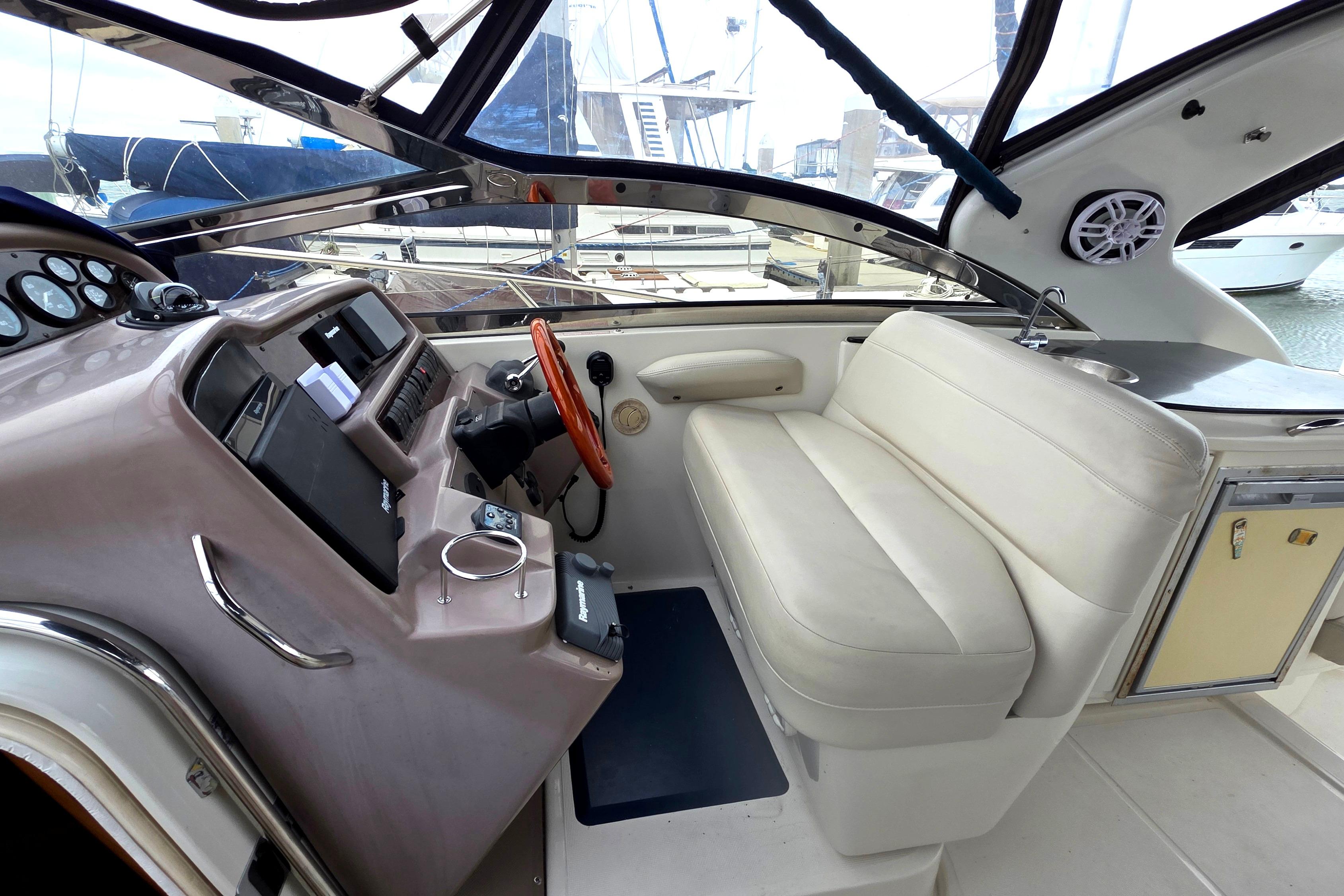 2002 Regal Commodore 4260 yacht cockpit with steering wheel and seating area.
