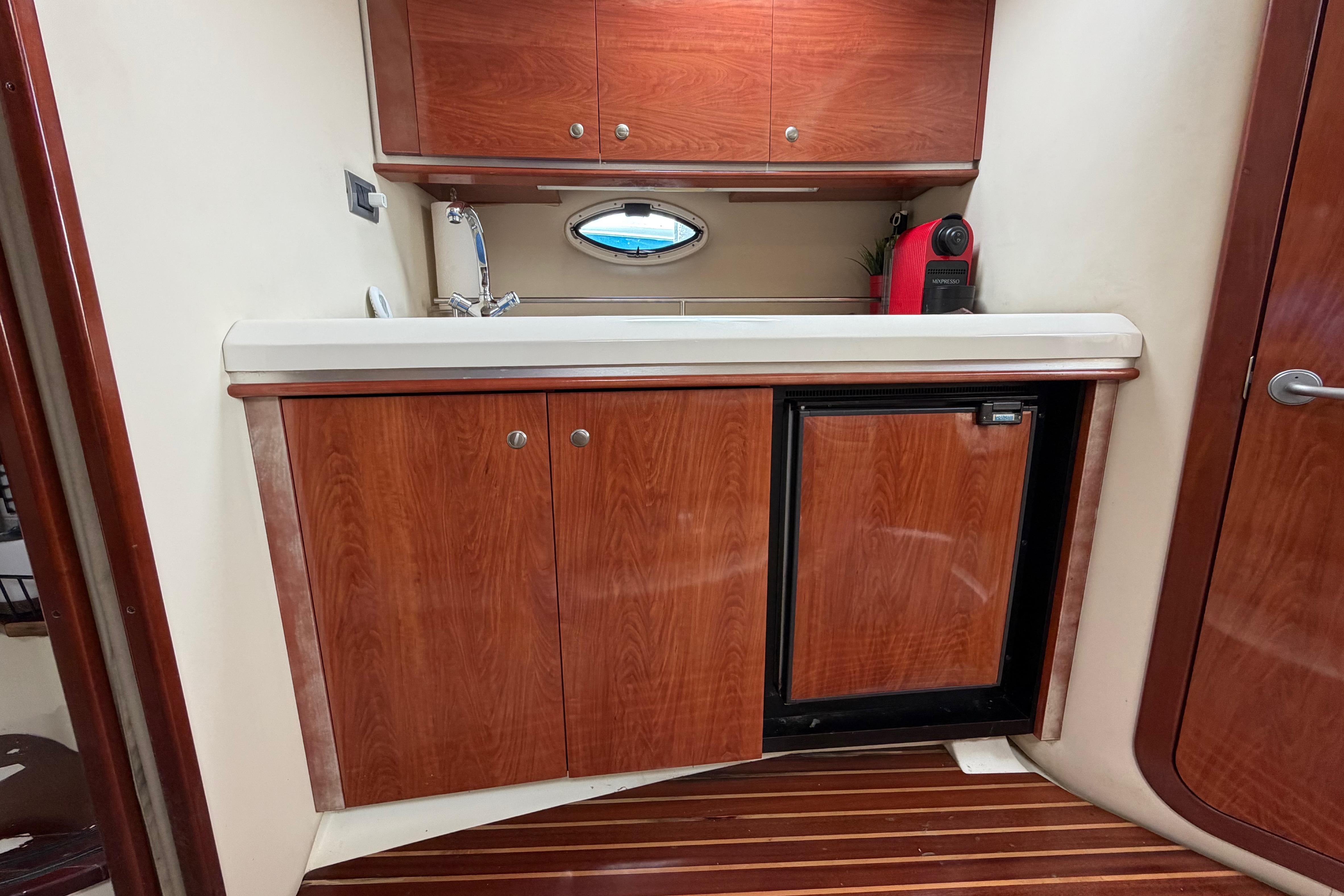 Interior of 2007 Monterey 350 Sport Yacht with wooden cabinetry and compact kitchenette.