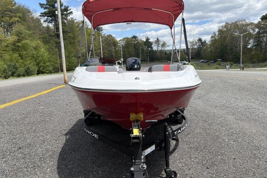 2026 Tahoe T16 boat with red canopy on trailer, parked on gravel road.