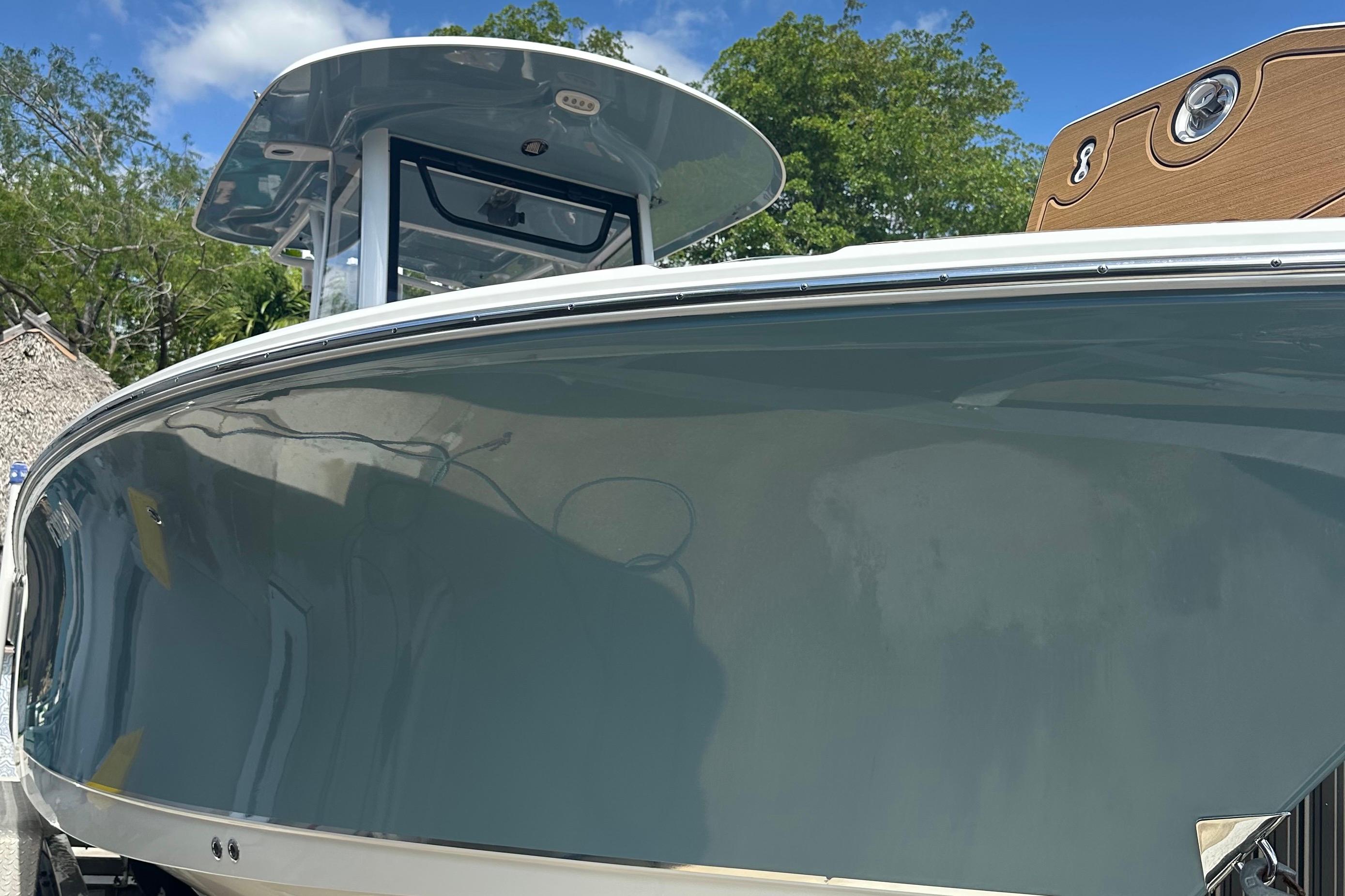 2019 Sea Hunt Gamefish 25 boat with sleek design, docked under a clear blue sky.