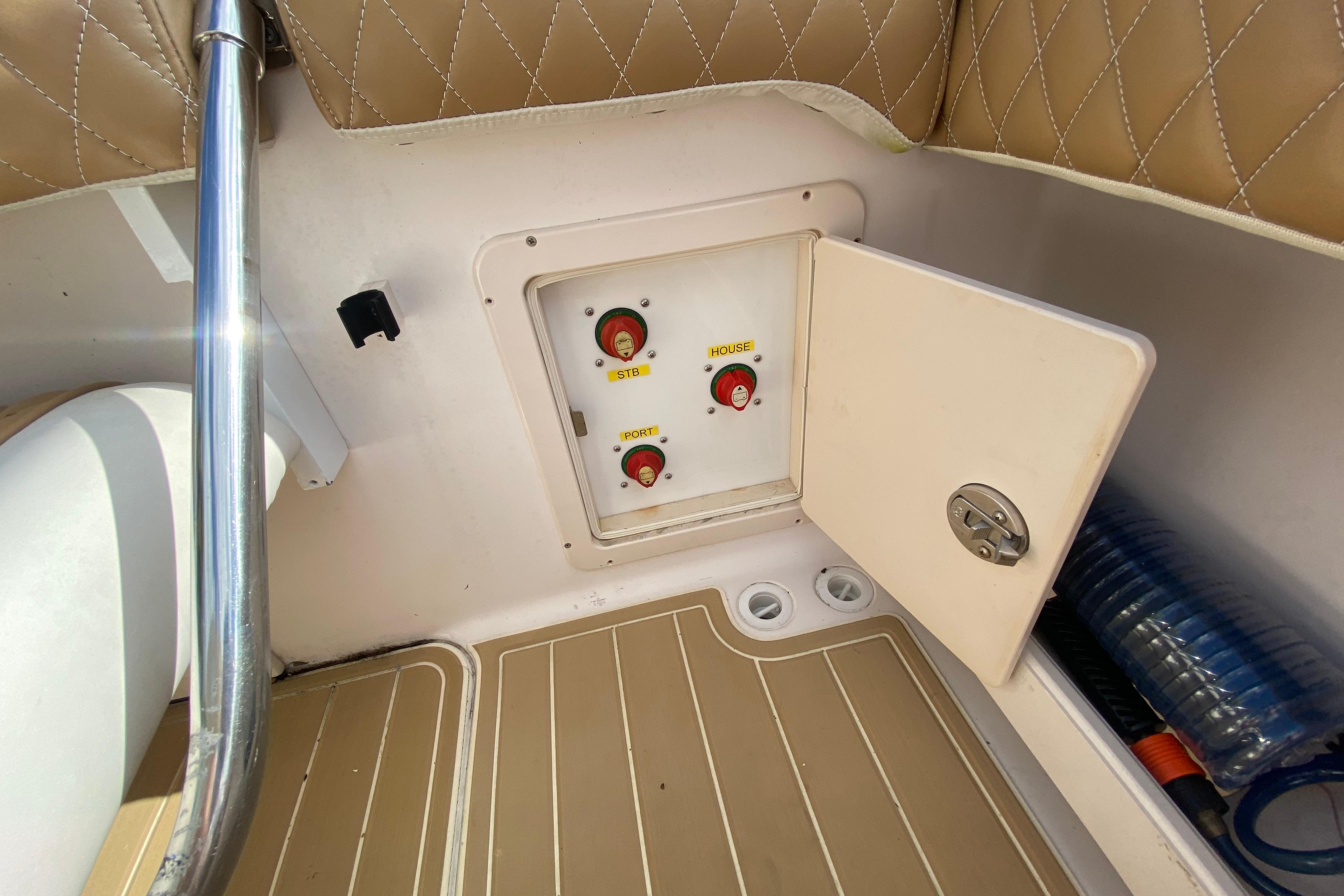 Control panel on 2004 Grady-White Canyon 283 boat with switches and storage compartment.