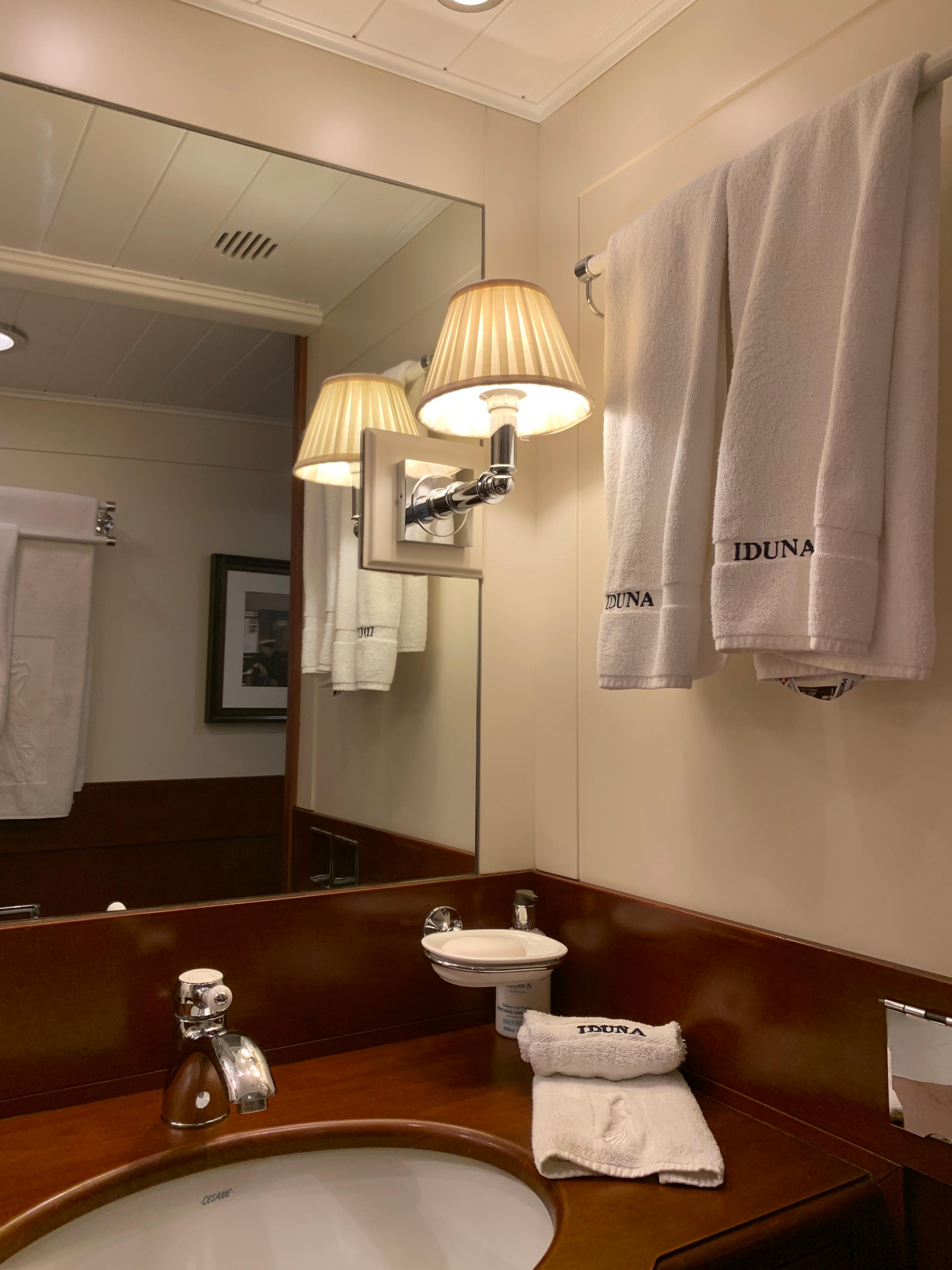 Bathroom interior of 1939 Feadship Classic Sailing Yacht with elegant fixtures and branded towels.