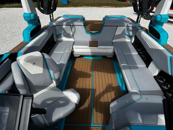 2022 Nautique S23 boat interior with sleek gray and blue seating and wood flooring.