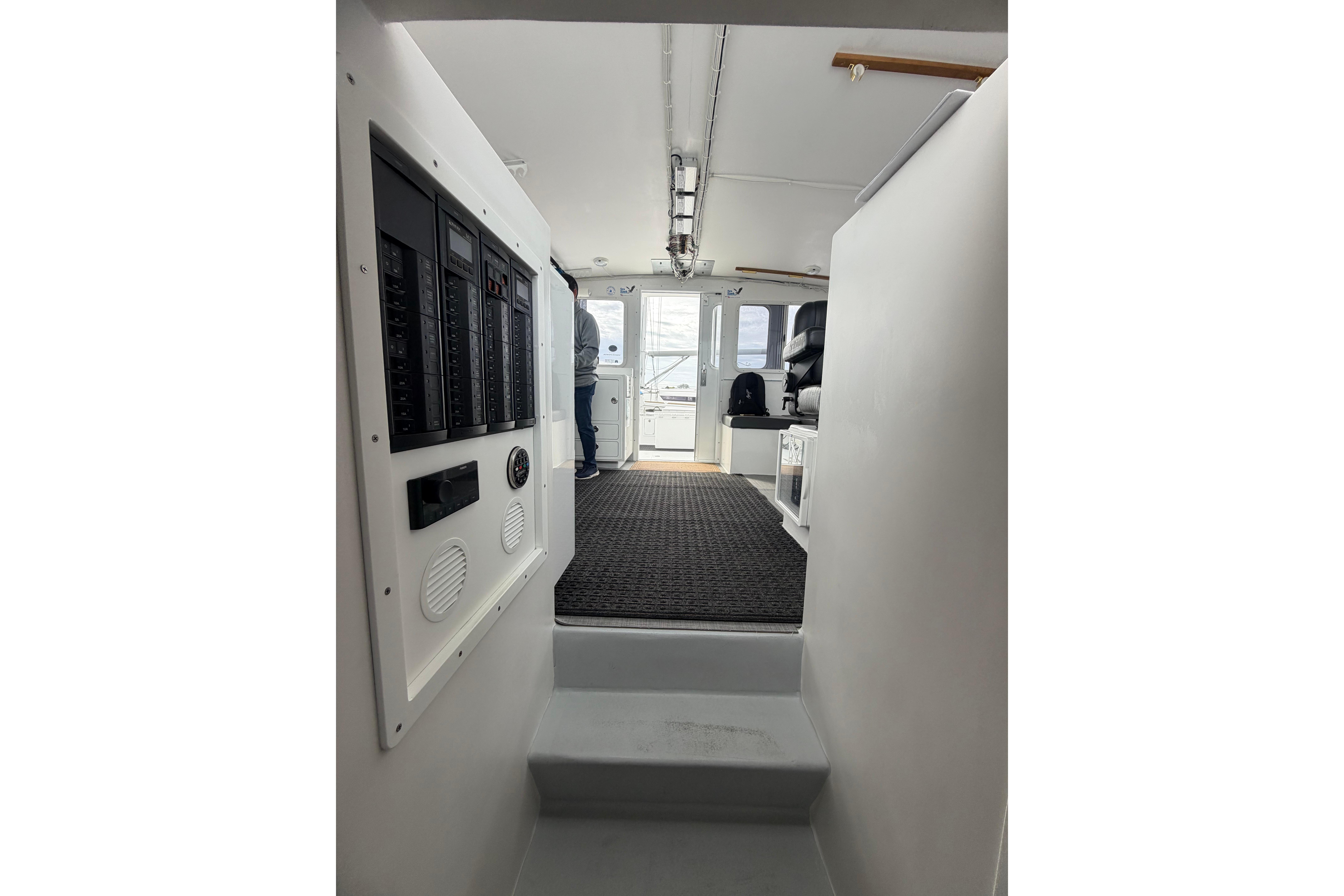 Interior view of 2018 H&H Marine Osmond Beal boat, featuring control panels and seating area.